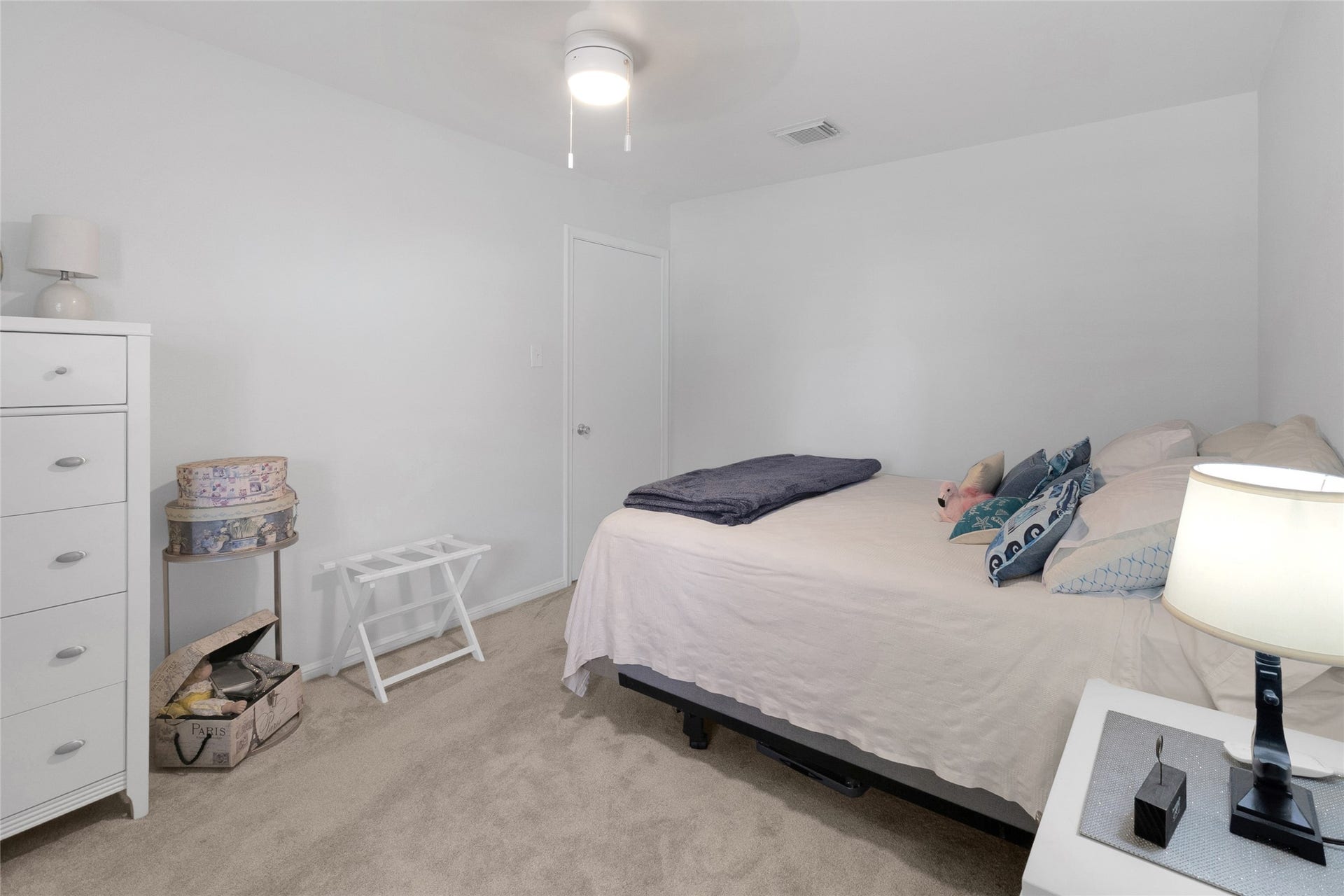 613 N Avenue F, Humble, TX 77338 Spacious bedroom featuring soft carpeting, a modern ceiling fan, warm lighting, and plenty of room to personalize to your liking.