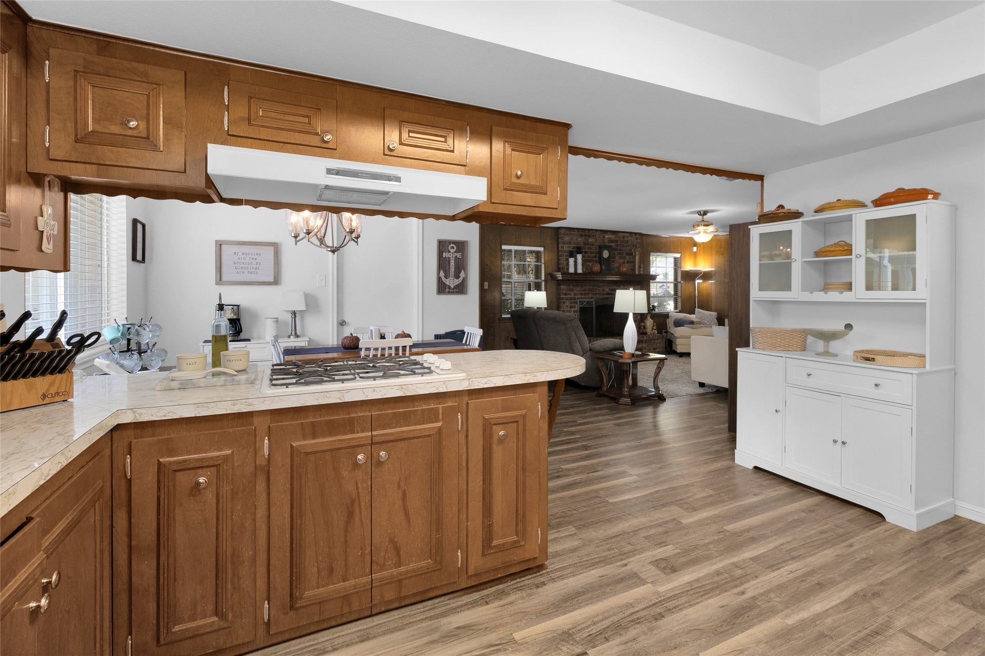 613 N Avenue F, Humble, TX 77338 Charming kitchen with warm wooden cabinetry and a cozy open layout leading to a spacious living area.