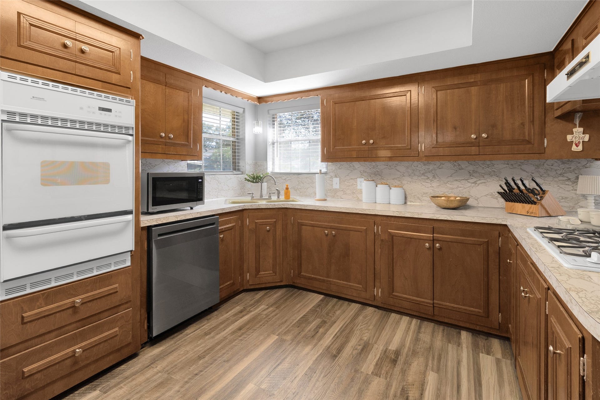 613 N Avenue F, Humble, TX 77338 Charming kitchen with rich wooden cabinetry, sleek countertops, and modern appliances, offering a warm and inviting atmosphere perfect for culinary enthusiasts.