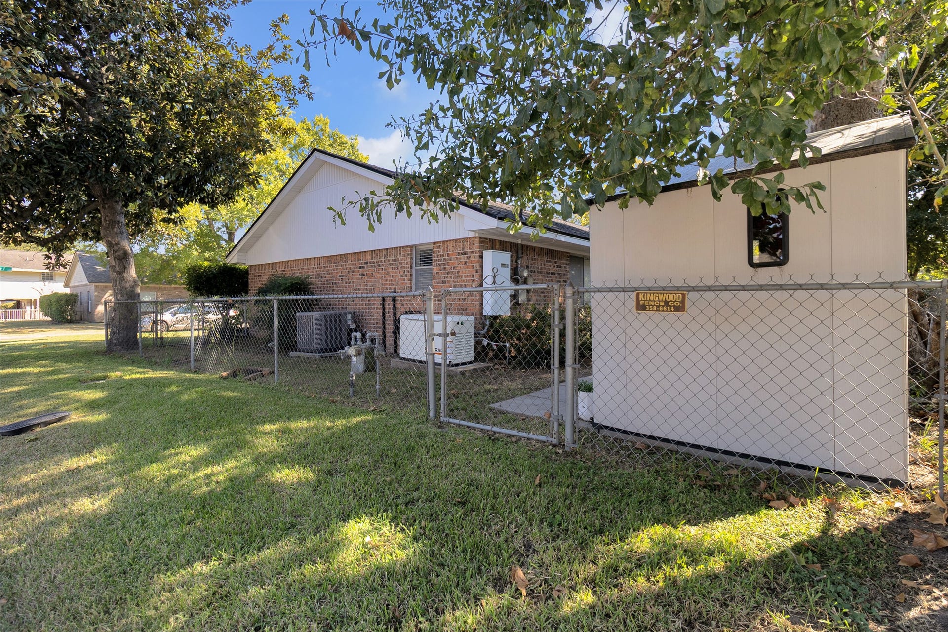 613 N Avenue F, Humble, TX 77338 Charming brick home with a fenced yard, mature trees, and a convenient storage shed, offering a perfect blend of privacy and utility.