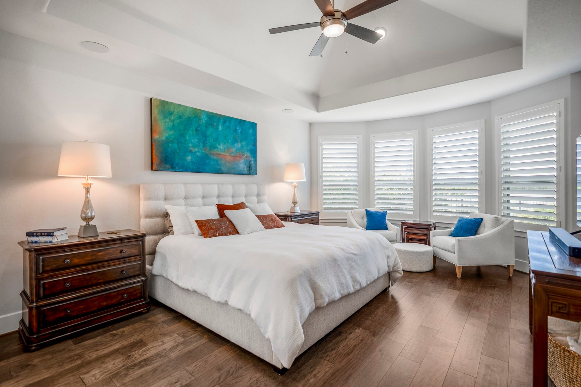 The primary bedroom, with a niche for seating and trayed ceiling.  Located at the back of the home, away from the 2 other downstairs bedrooms.