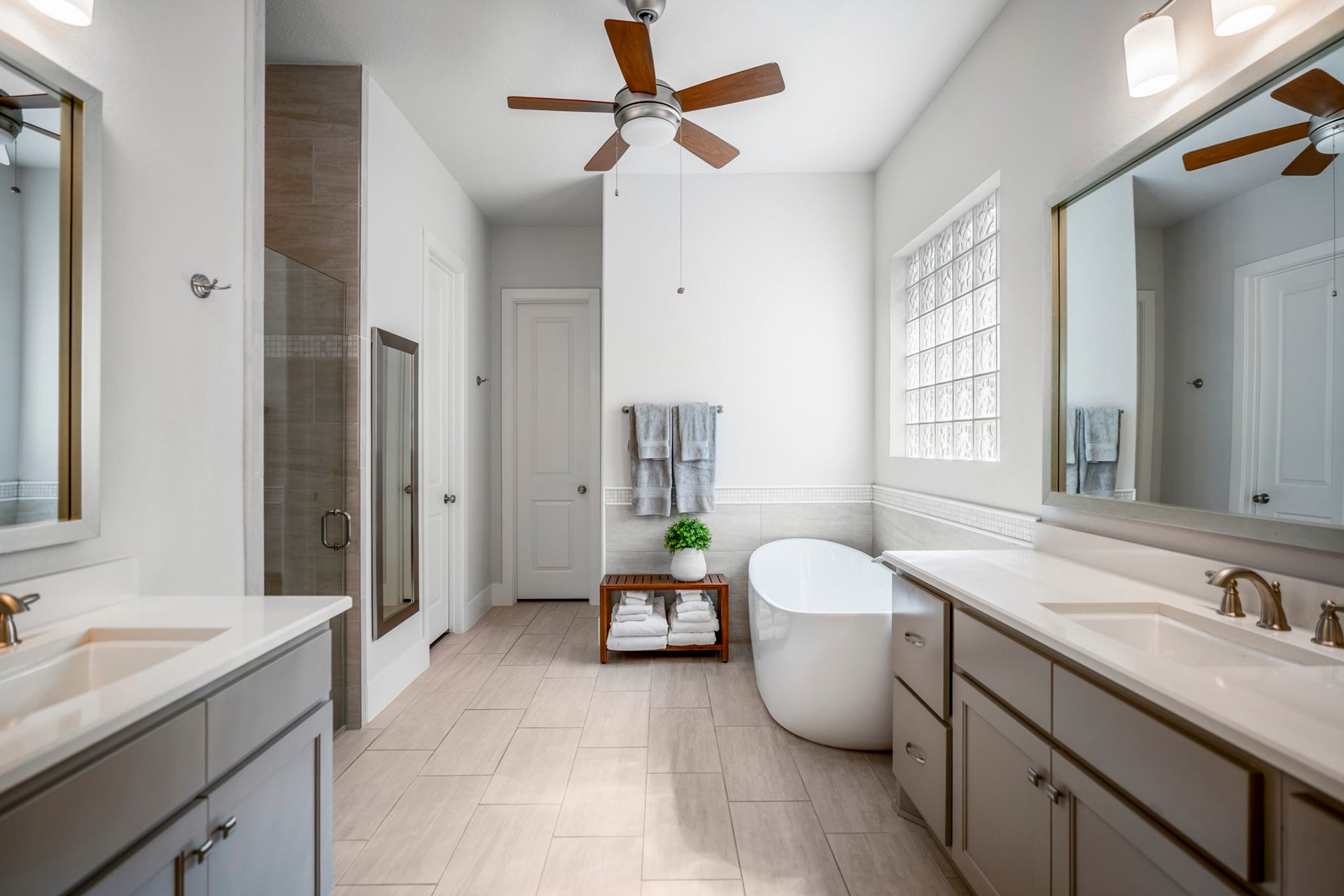 The primary bath has a shower and tub, along with his and hers vanities.