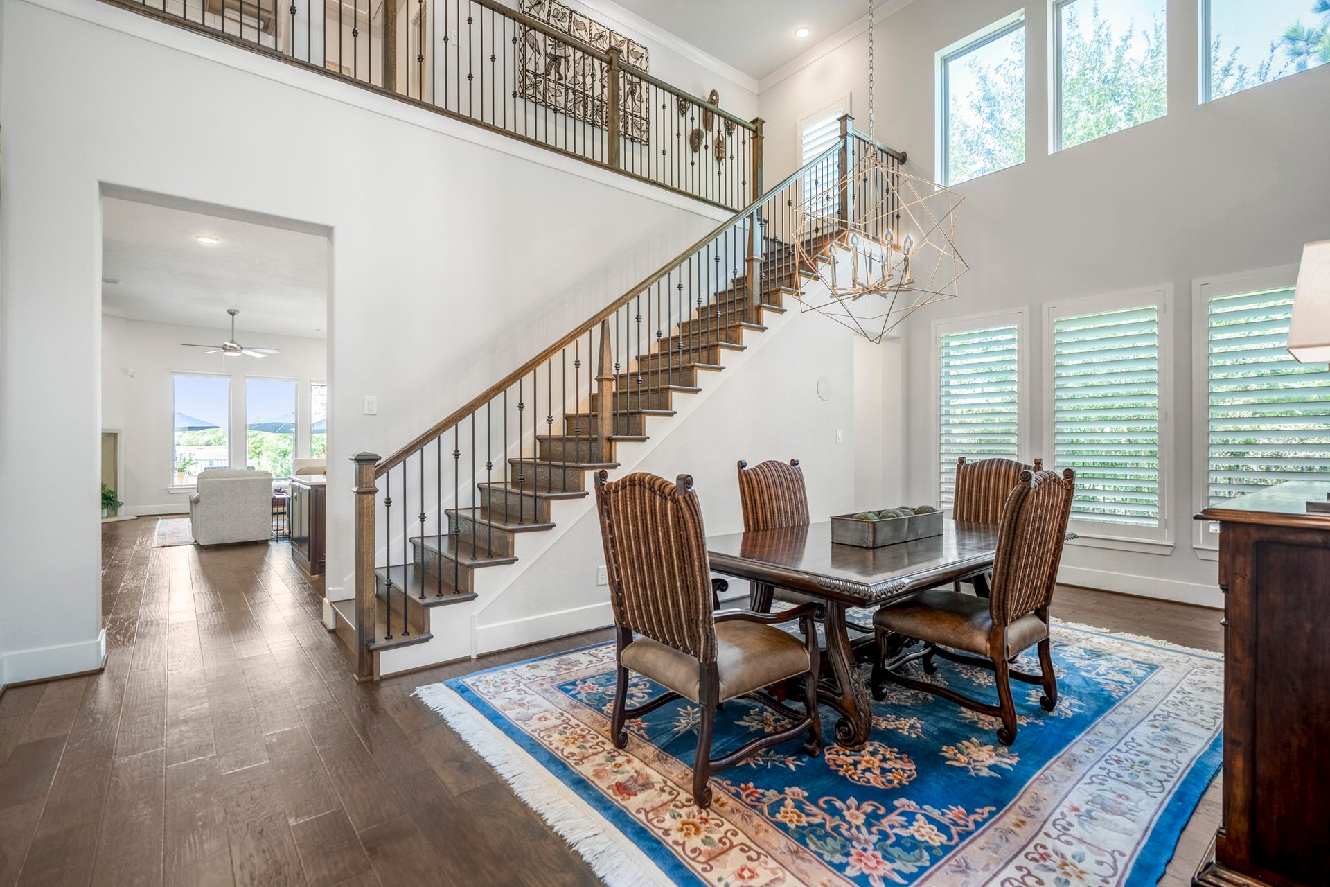 As you continue into the home, your next stop is this stunning dining room, with 2 story ceilings with beams  and a wall of windows looking out to the greenbelt.