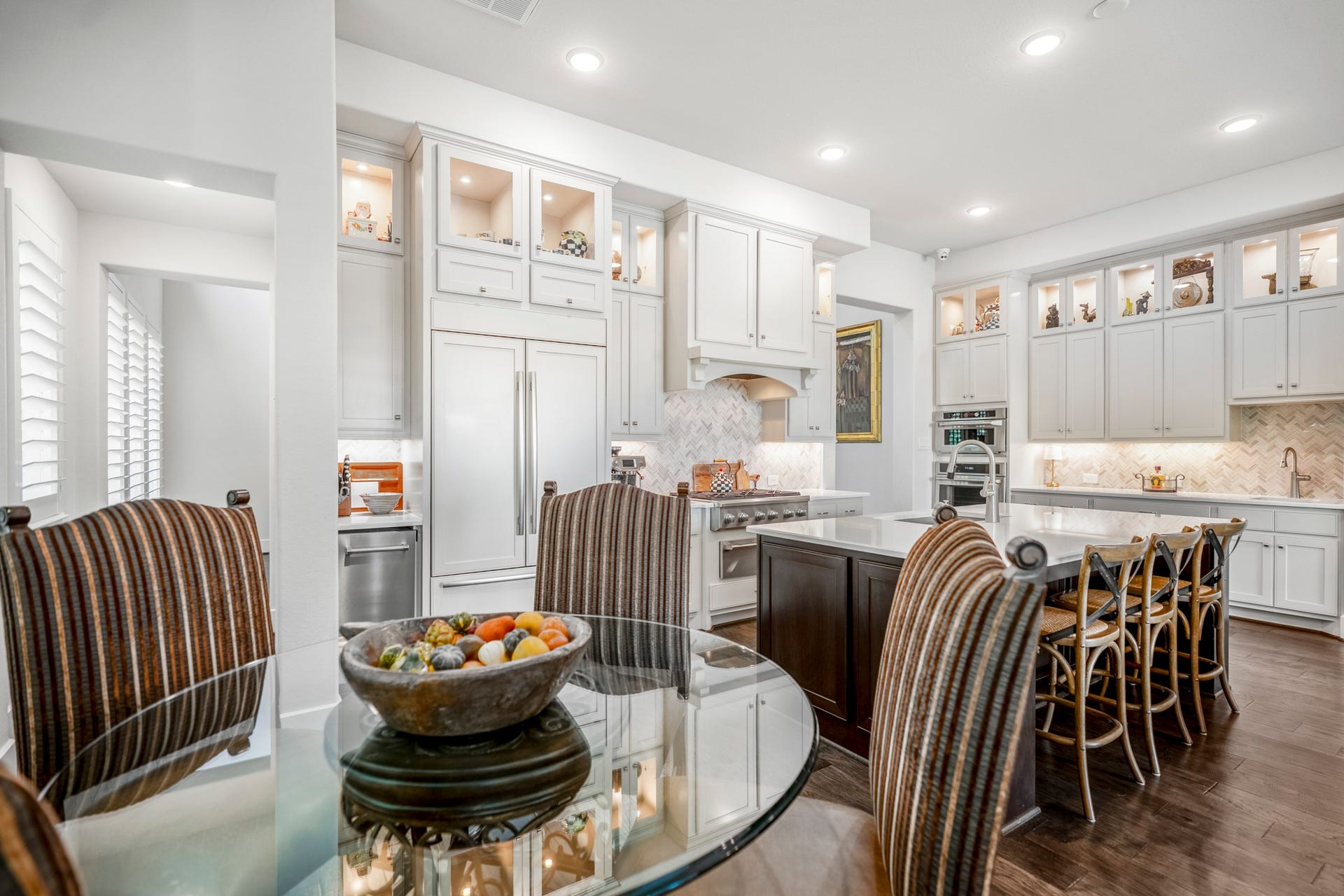 The breakfast room and kitchen, with additional seating at the island.  You can see into the dining room down the short hall to your left.  The walk-in pantry is located there as well.