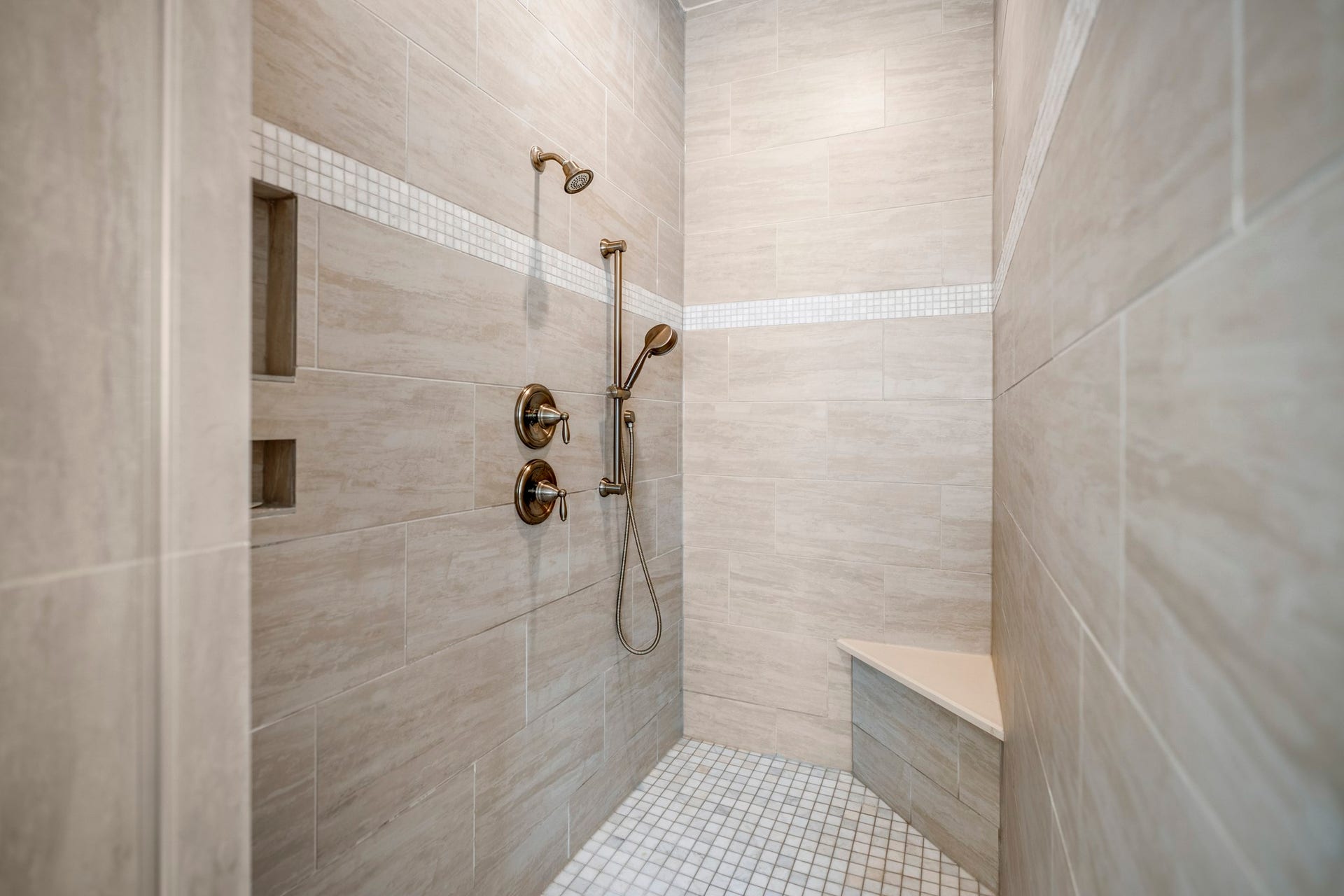 The shower offers multiple shower heads and a corner seat.