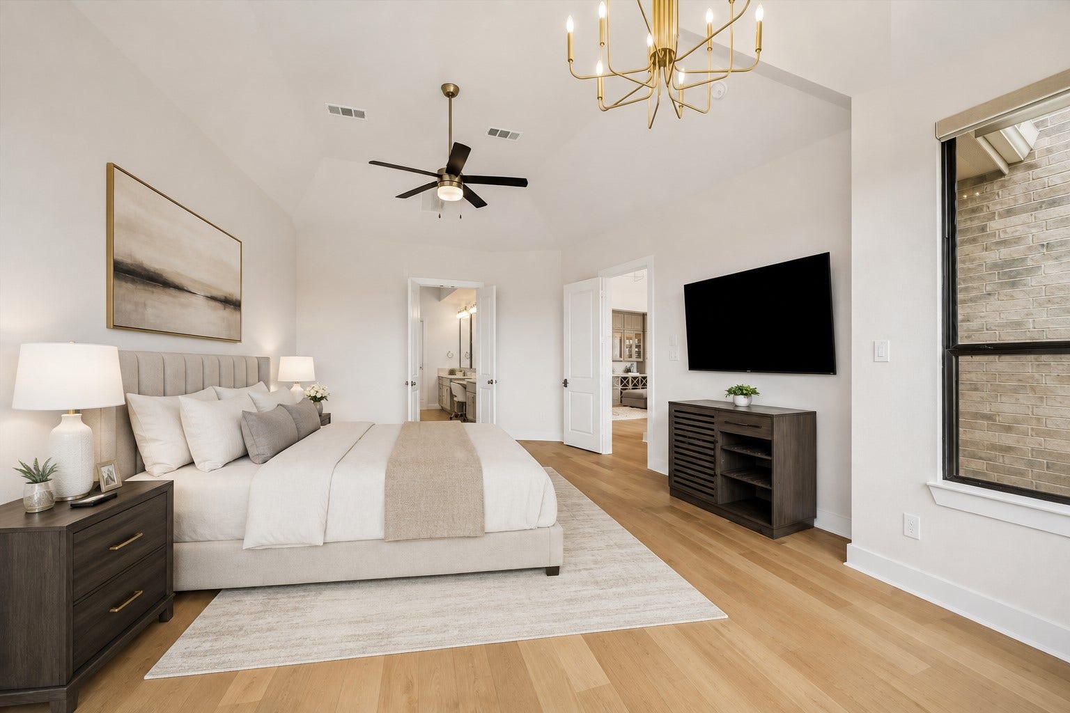 ANOTHER VIEW OF THE PRIMARY BEDROOM HIGHLIGHTS THE VAULTED CEILING, GENEROUS ROOM SIZE, WOOD FLOORING, AND DIRECT ACCESS TOWARD THE EN SUITE BATH. **Virtually Staged.