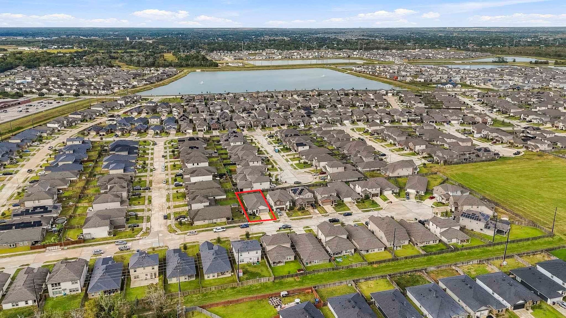 903 Pismo Lane, Rosharon, TX 77583 This impressive aerial view showcases an expansive residential community featuring beautifully arranged homes, well-maintained streets, and spacious green areas. A large scenic lake with decorative fountains serves as a stunning centerpiece, enhancing the neighborhoods peaceful and inviting atmosphere.