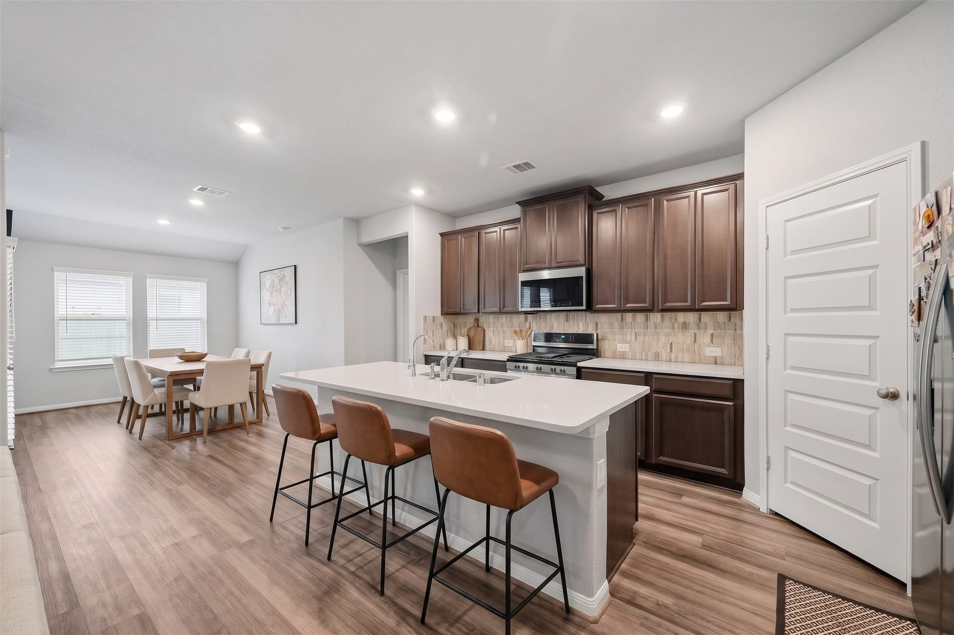 903 Pismo Lane, Rosharon, TX 77583 Virtually Staged: This beautifully designed kitchen and dining area features a seamless open-concept layout, with the dining space conveniently located just steps from the kitchen for effortless meal preparation, serving, and entertaining.