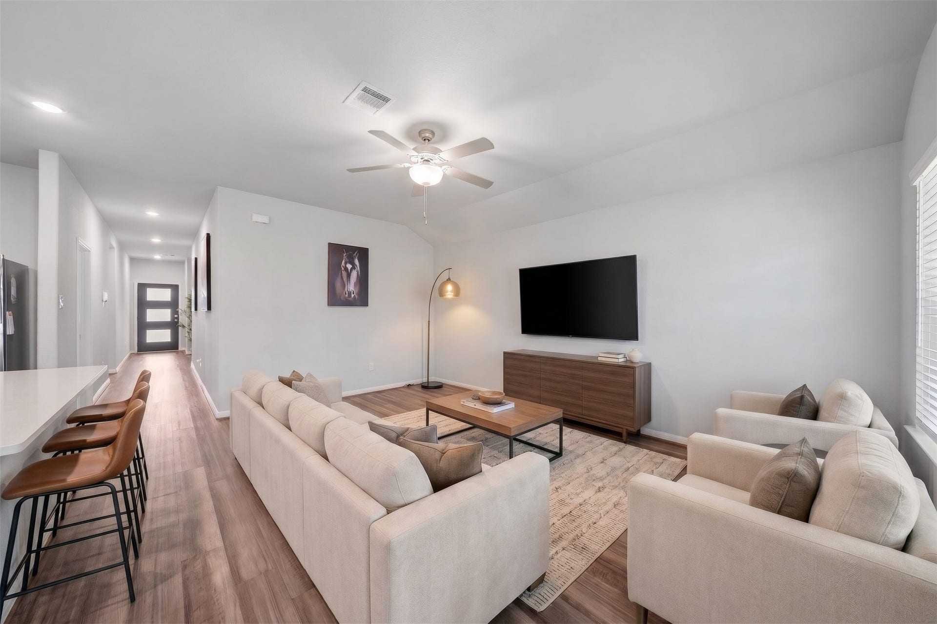 903 Pismo Lane, Rosharon, TX 77583 Virtually Staged: The living room features an open-concept layout with beautiful flooring, soft neutral walls, and a vaulted ceiling that enhances the rooms bright, airy atmosphere.