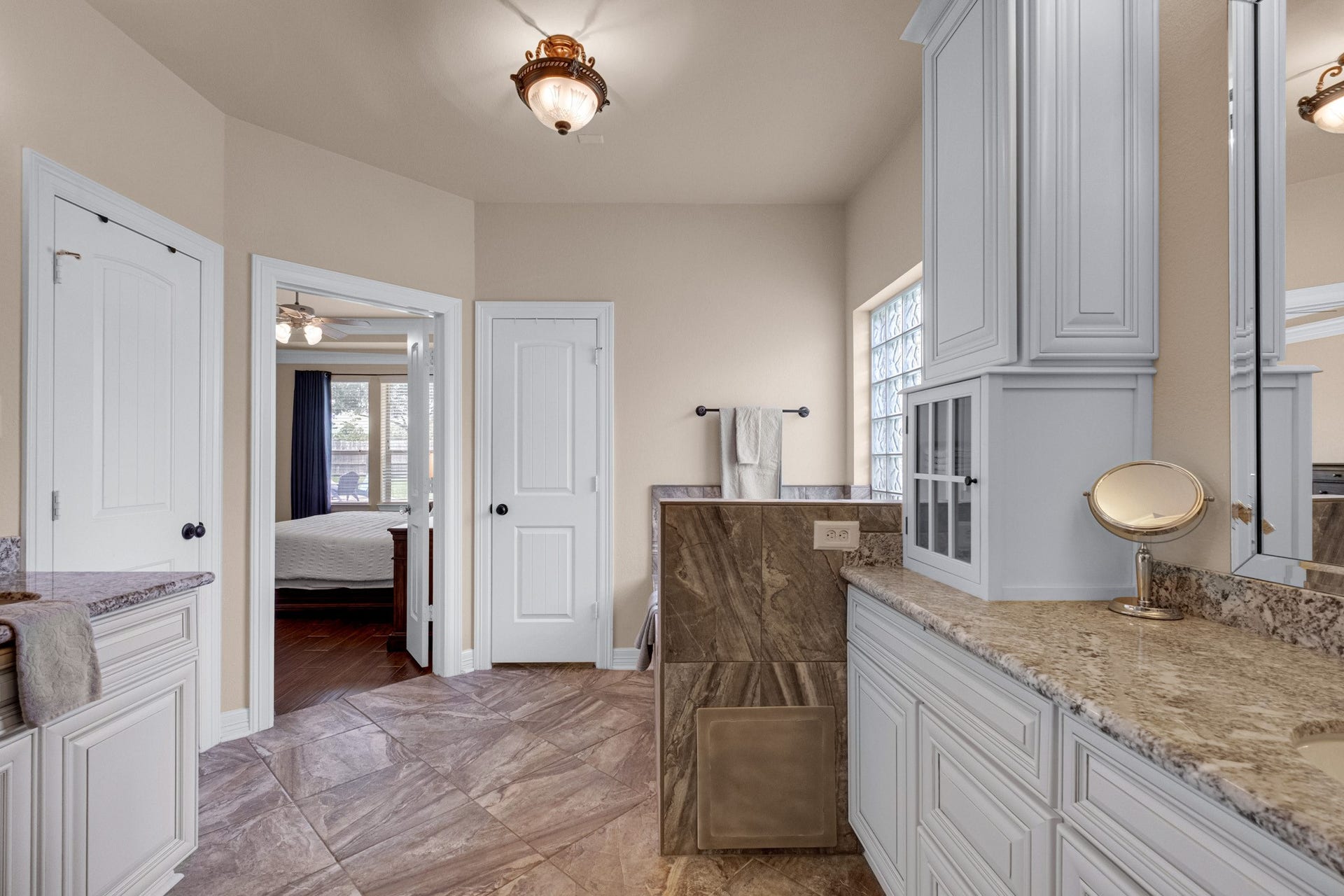 440 Old Orchard Court, Dickinson, TX 77539 Travertine-look tile runs the floor and tub deck, with a linen tower, private water closet, and a direct door back to the bedroom.