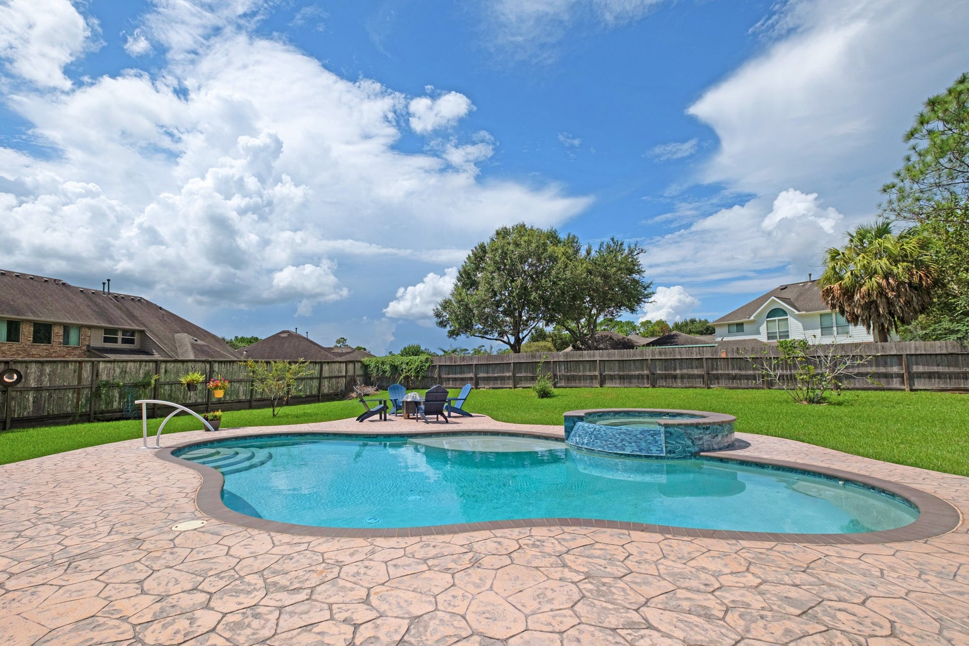 440 Old Orchard Court, Dickinson, TX 77539 Wide open to the sky, the pool and spa sit ringed in stamped concrete with mature trees along the fence line and plenty of lawn left over.