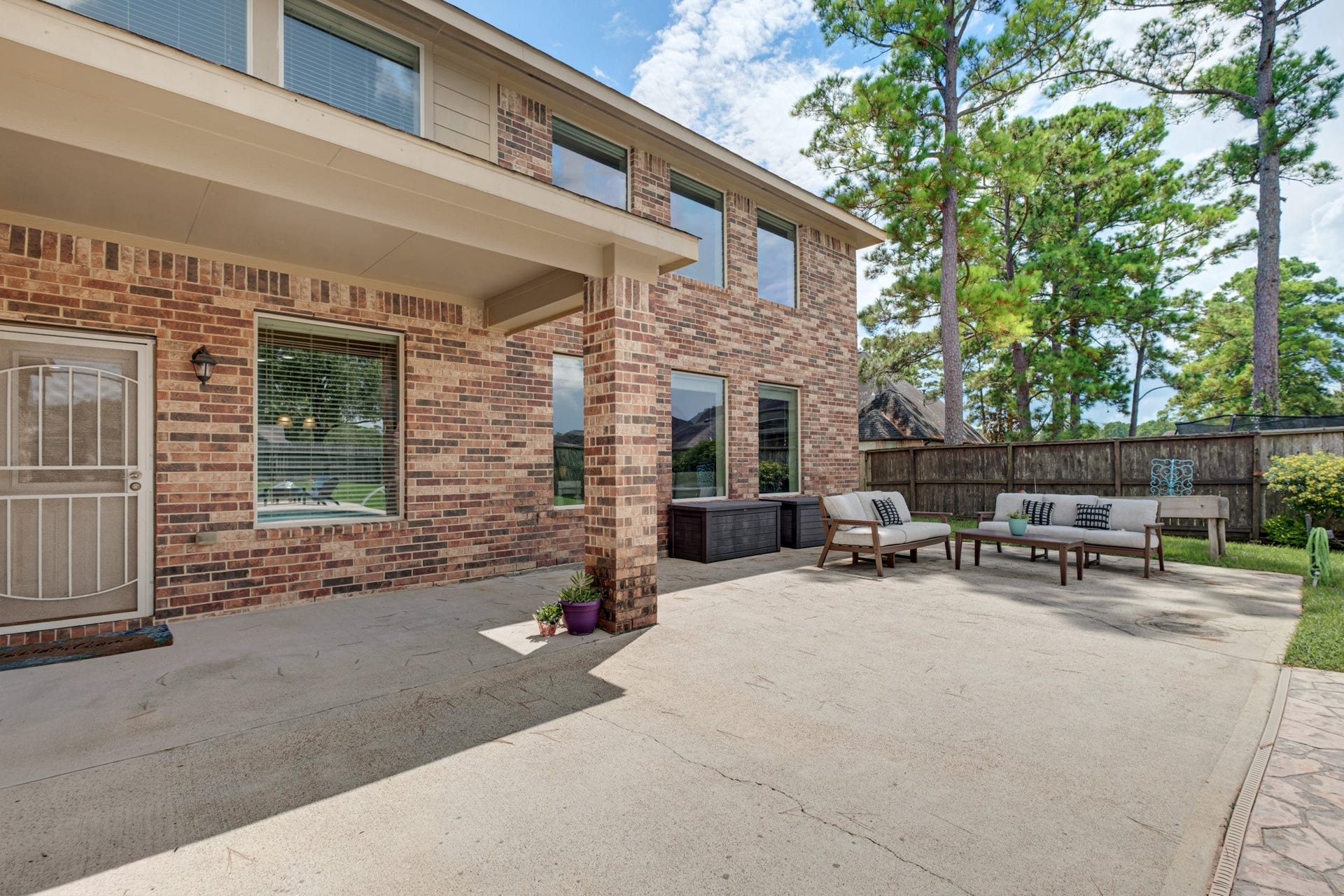 440 Old Orchard Court, Dickinson, TX 77539 The covered patio extends off the back of the home in brick and beam, with room for a full seating group and a straight shot out to the pool deck.