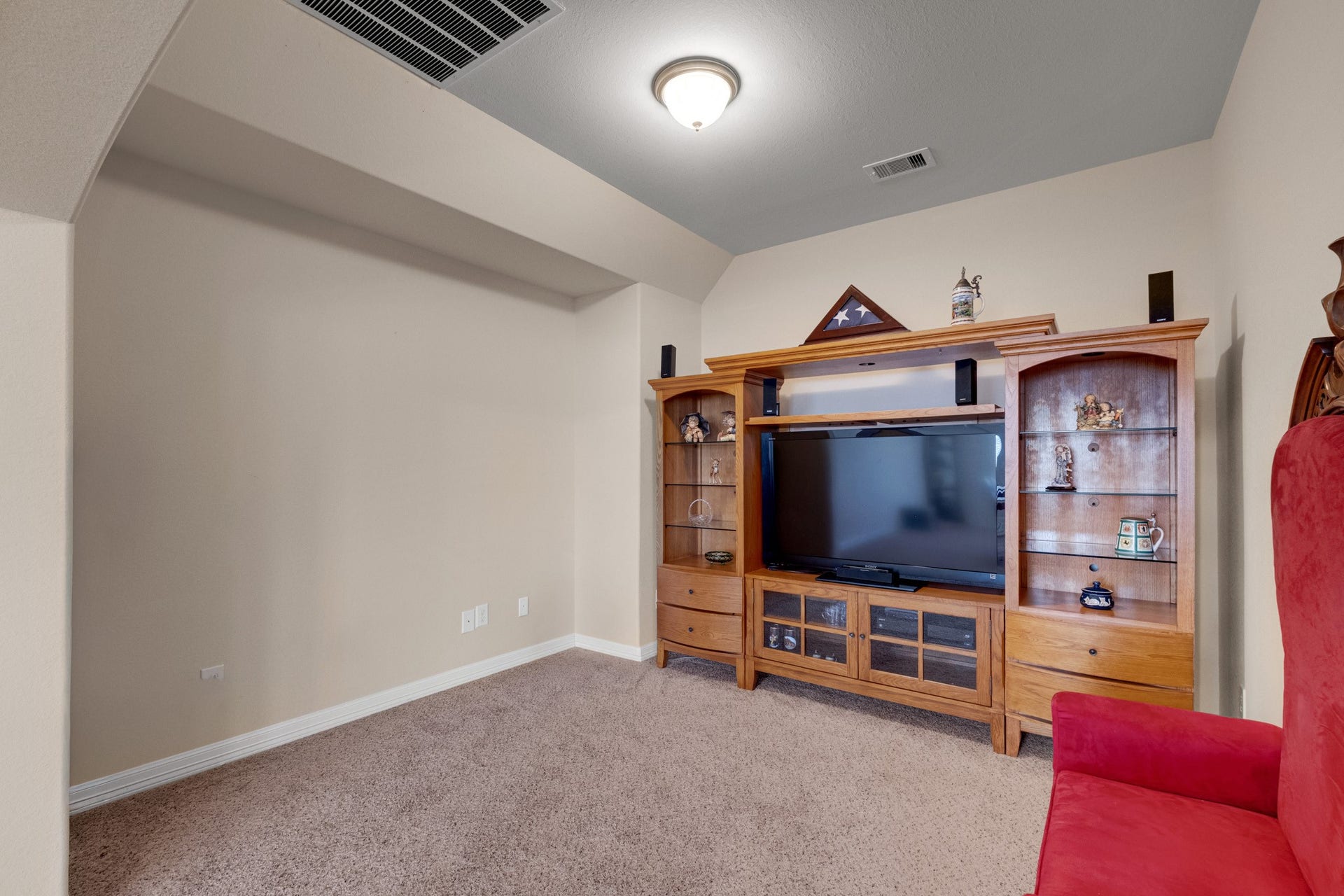 440 Old Orchard Court, Dickinson, TX 77539 A dedicated media room sits tucked off the game room, wrapped in plush carpet with a stepped ceiling and a full wall staged for the screen - set back far enough from the landing to keep movie nights to themselves.