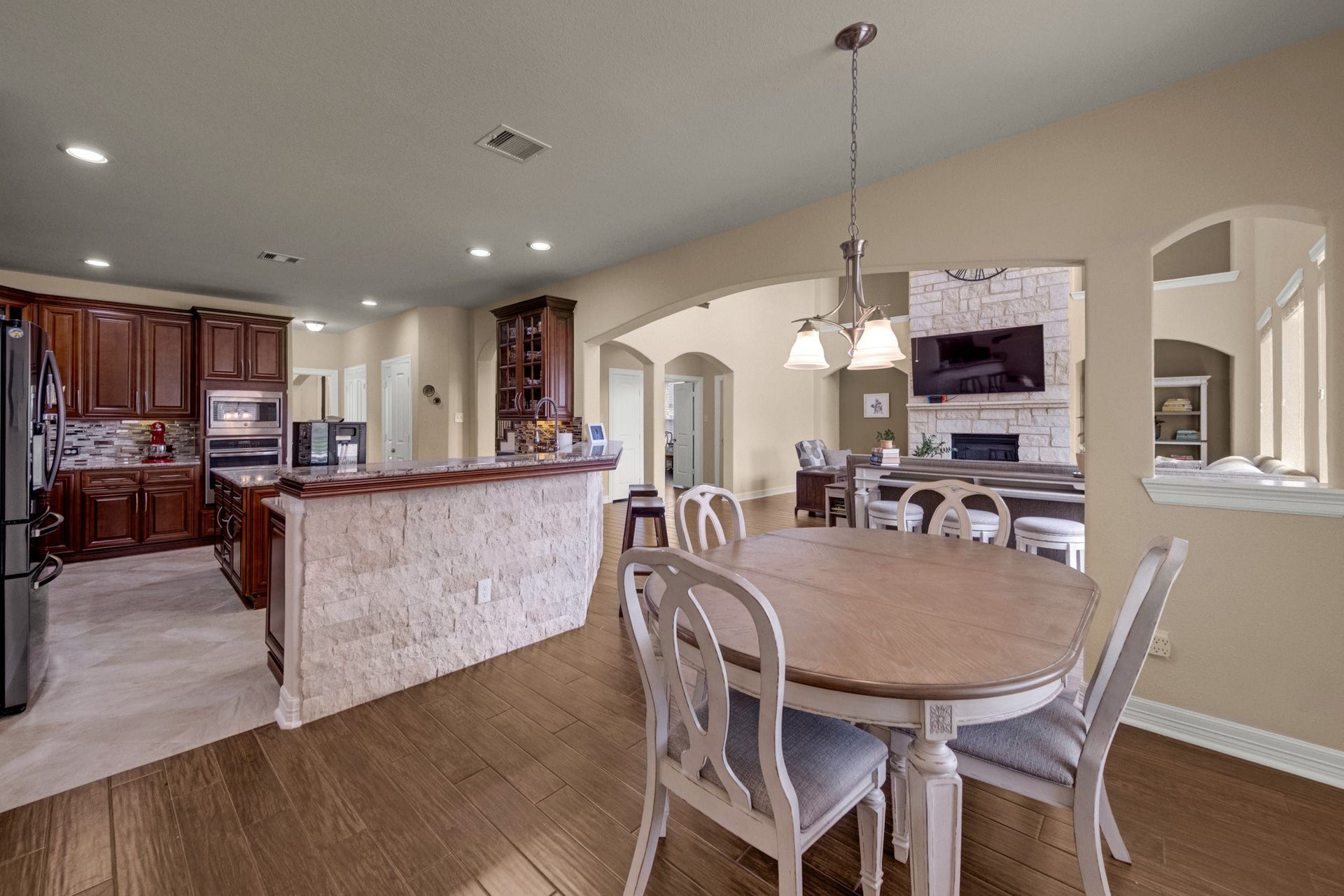 440 Old Orchard Court, Dickinson, TX 77539 A breakfast bar in split-face silver travertine ledgestone separates the kitchen from the casual dining and keeps the whole rear of the home connected to the family room fireplace.