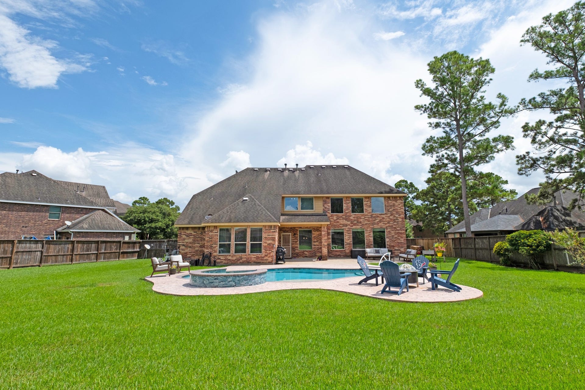 440 Old Orchard Court, Dickinson, TX 77539 The full width of the backyard shows what the lot really offers - pool and deck on one side, a broad open run of turf on the other.
