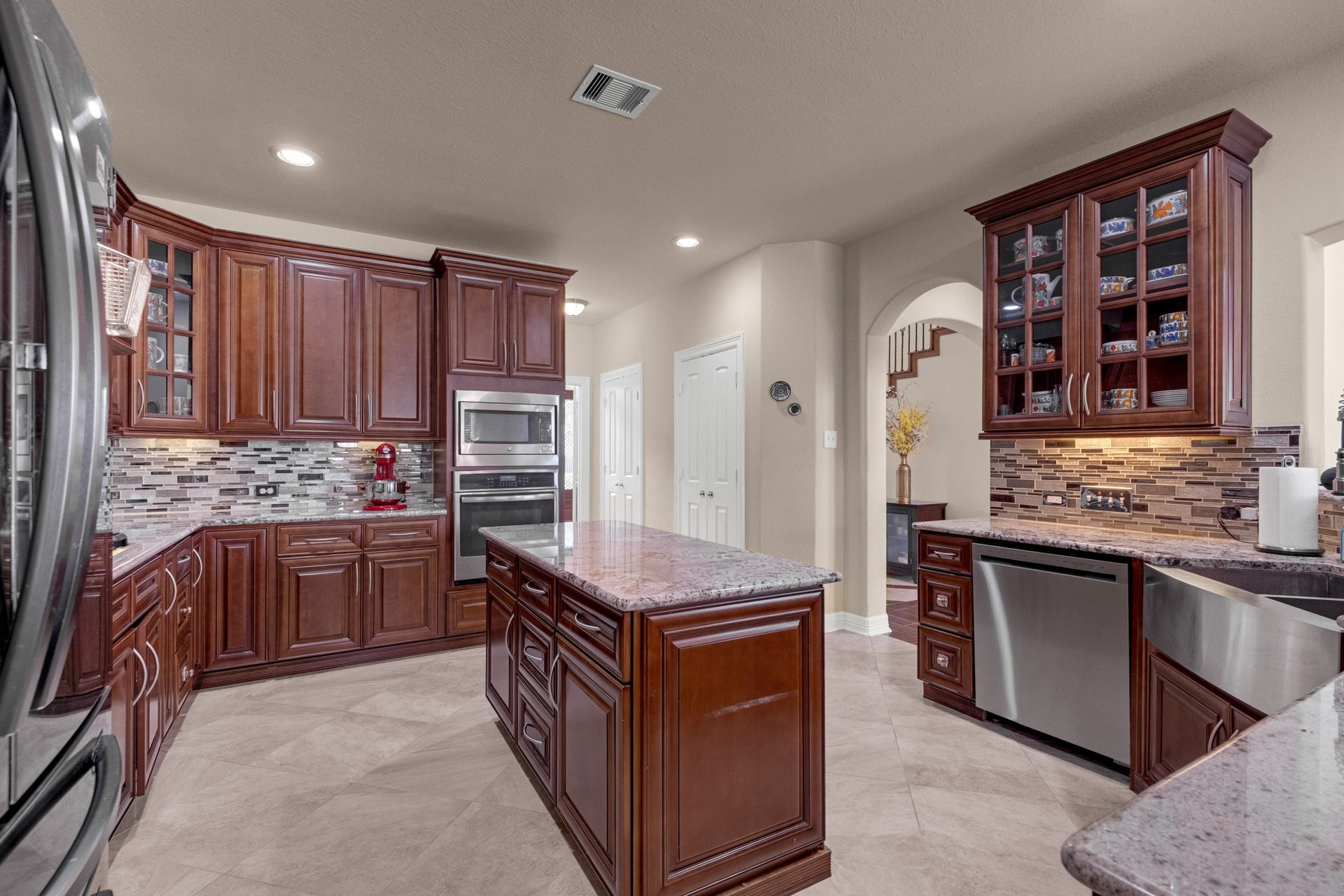 440 Old Orchard Court, Dickinson, TX 77539 The kitchen works as hard as it looks - a granite-topped island, glass-front display uppers, undercabinet lighting, stainless dishwasher, and a coffee-bar run tucked against the breakfast side.