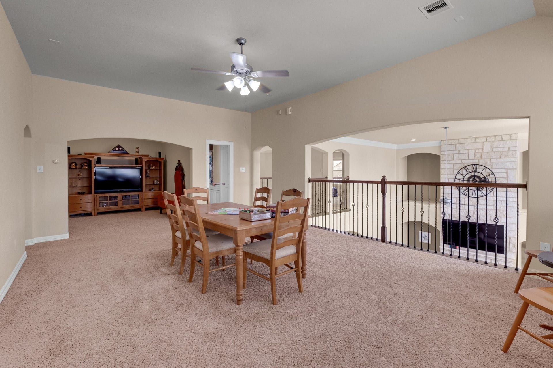 440 Old Orchard Court, Dickinson, TX 77539 The upstairs game room opens over an iron-railed overlook to the family room below, with a media wall and room for a full-size table alongside.