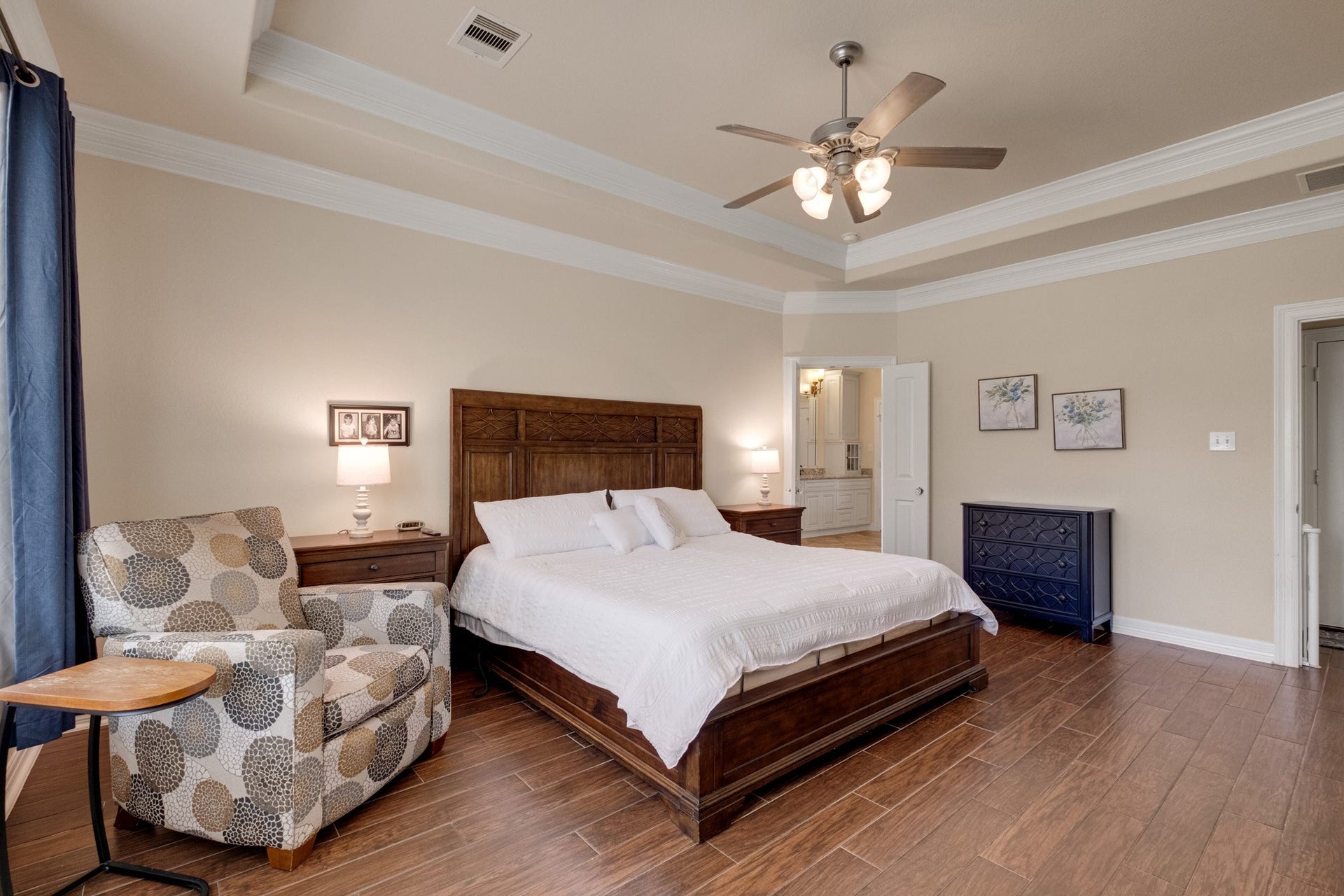 440 Old Orchard Court, Dickinson, TX 77539 From the doorway, the primary suite reads generously - tray ceiling with crown, ensuite framed in the corner, and enough room for a king plus a sitting area.