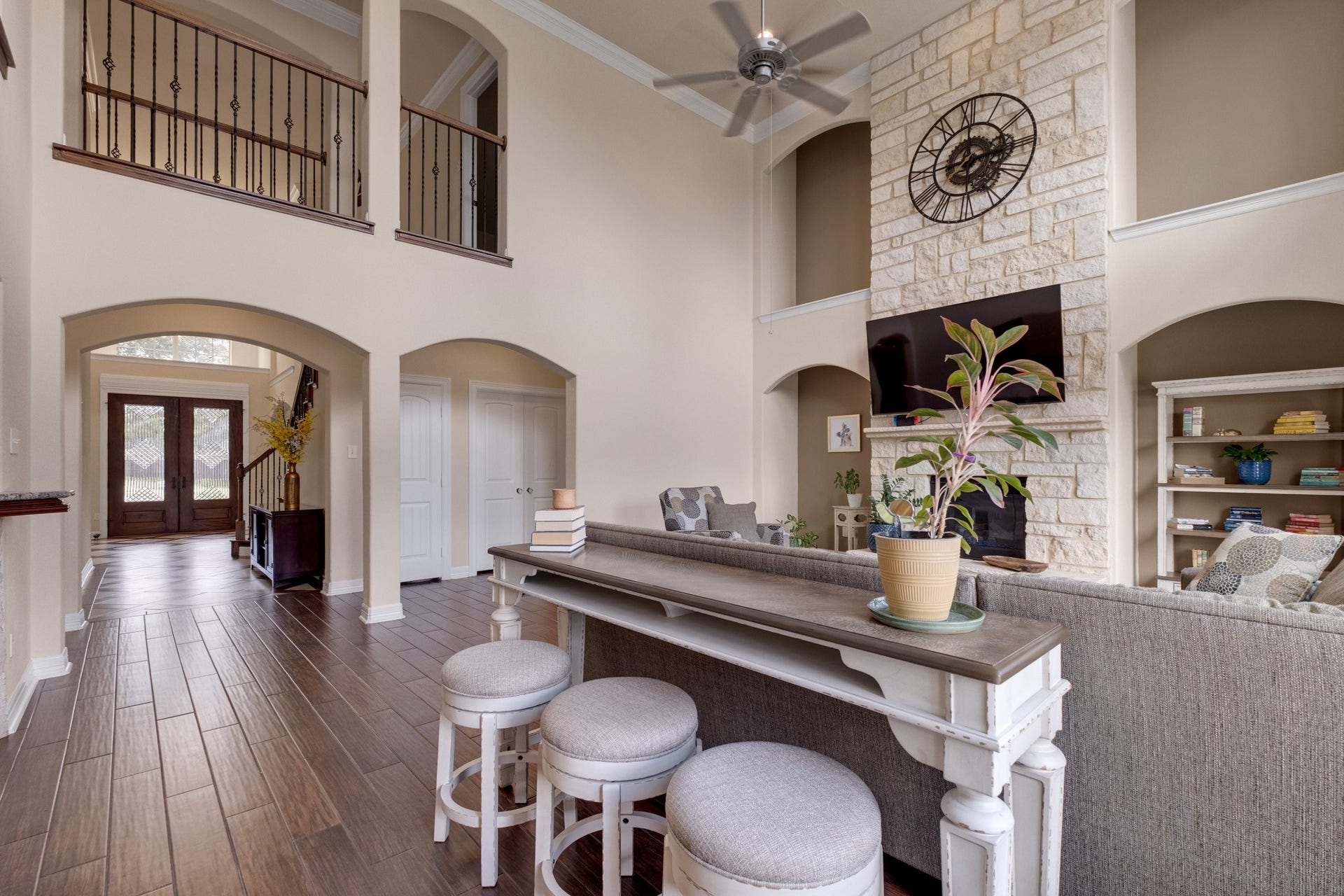 440 Old Orchard Court, Dickinson, TX 77539 Turning toward the foyer, the arched openings and iron-railed catwalk tie the two stories together while mahogany wood tile runs continuously through the main level.
