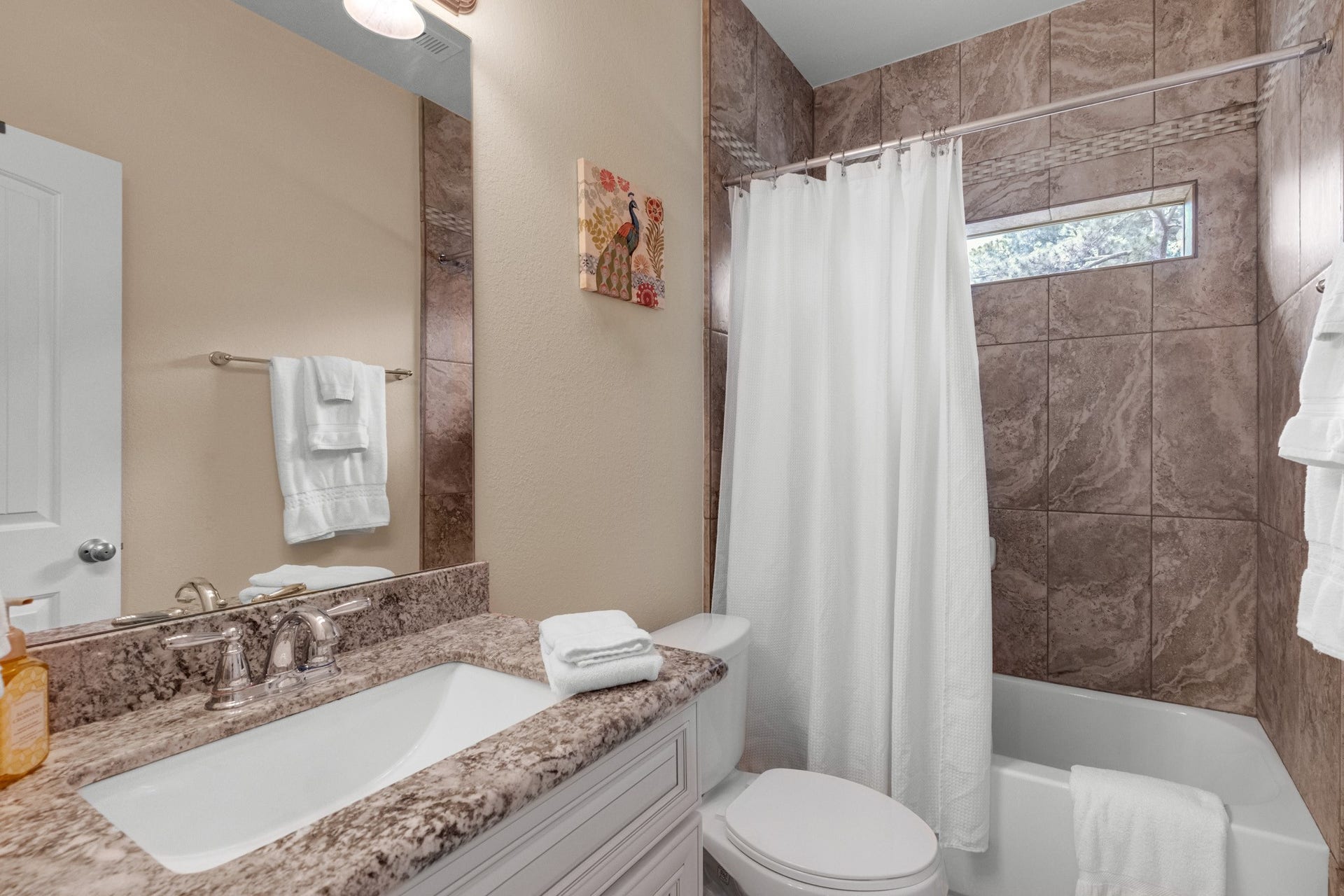 440 Old Orchard Court, Dickinson, TX 77539 A secondary full bath carries the finishes through - large-format tile tub surround with mosaic accent band, granite-topped vanity, and a privacy window over the tub.
