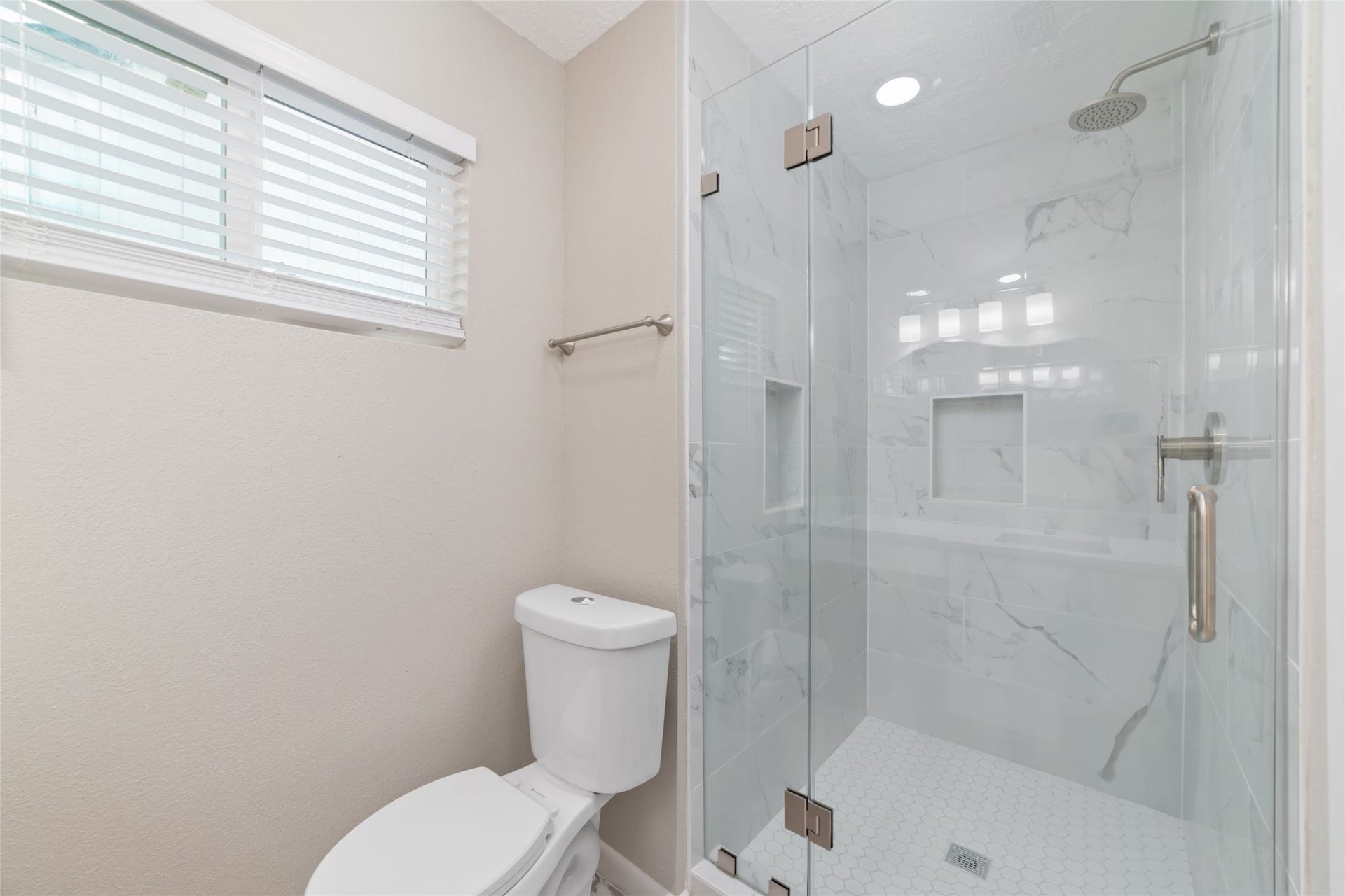 2830 Westerland Drive, Houston, TX 77063 Fresh tile and a glass-enclosed oversized shower bring a polished finish to your private primary suite.