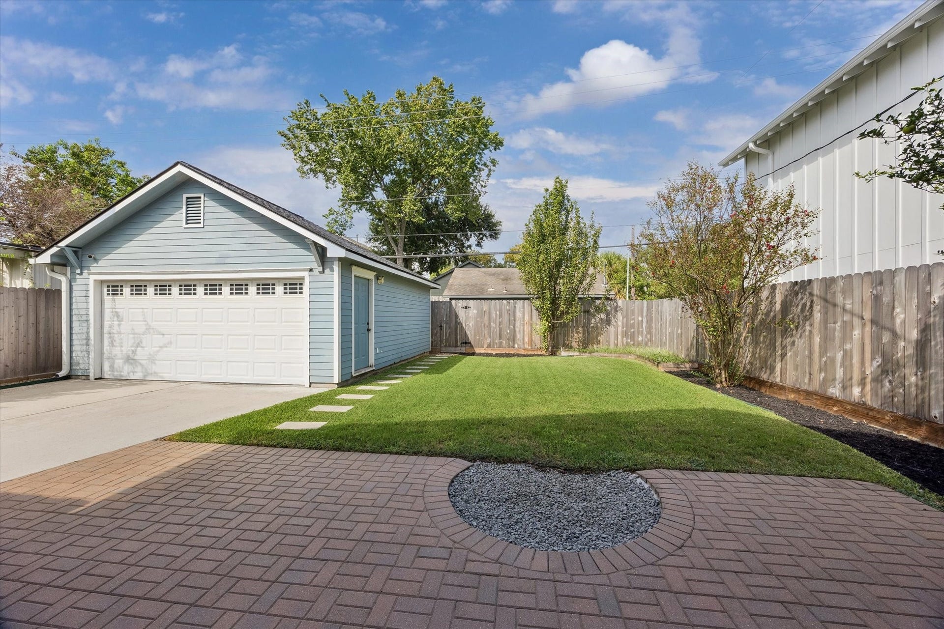 Amazing back yard space with grass, patio and two car garage