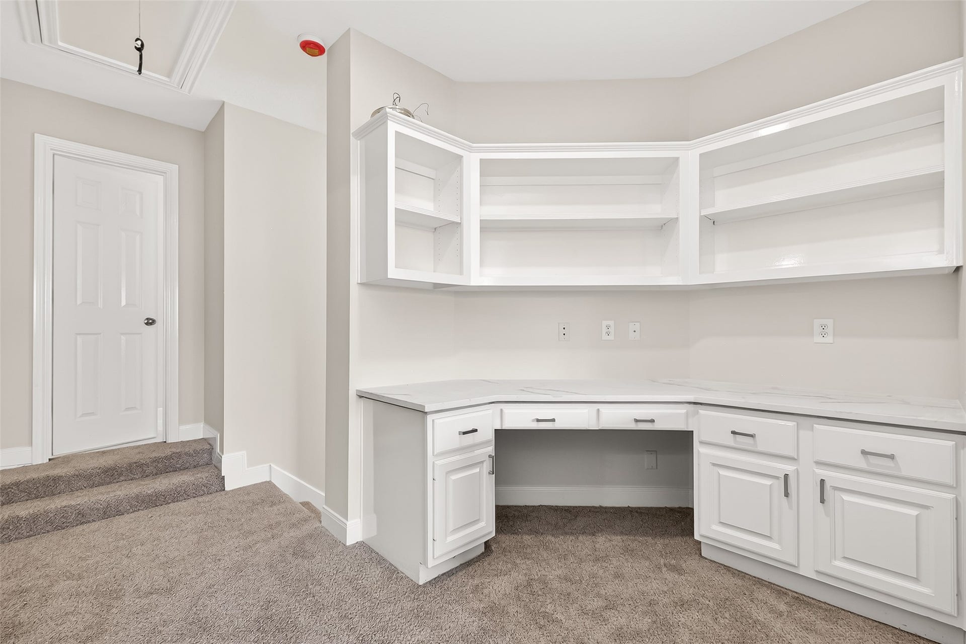 3610 Forest Row Drive, Houston, TX 77345 Bright and spacious home office area with built-in white cabinets and open shelving, offering ample storage and workspace.