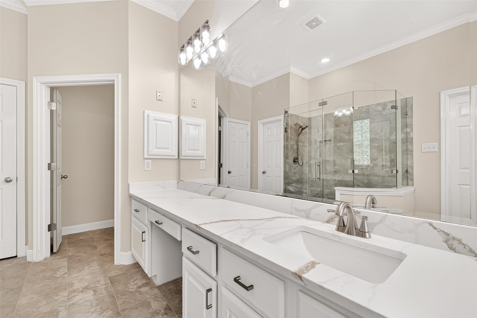 3610 Forest Row Drive, Houston, TX 77345 Luxurious bathroom featuring a double vanity with sleek marble countertops and a spacious glass-enclosed shower, offering a blend of elegance and functionality.