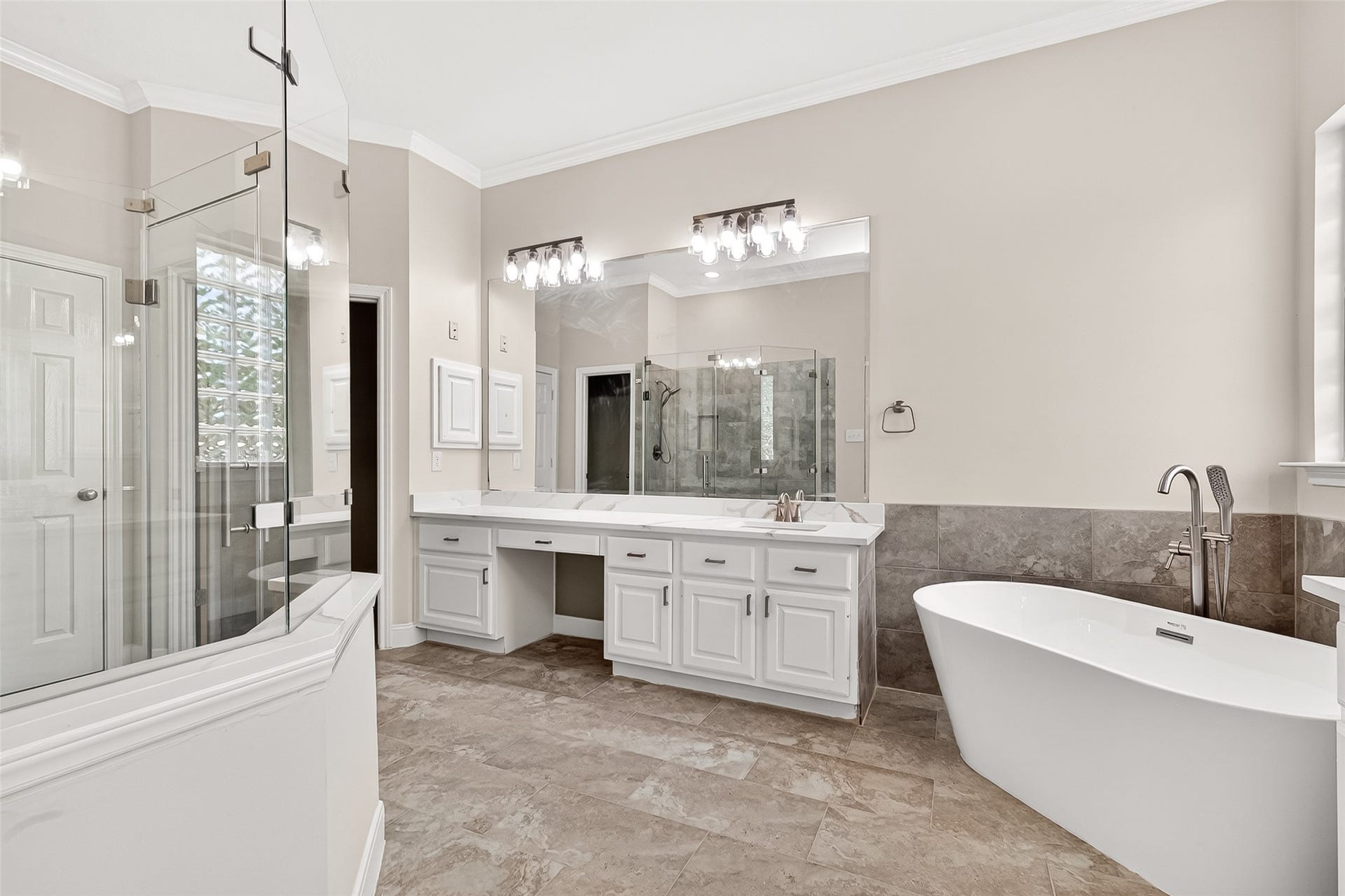3610 Forest Row Drive, Houston, TX 77345 Luxurious bathroom featuring a sleek freestanding tub, spacious glass-enclosed shower, and dual-sink vanity with elegant lighting.