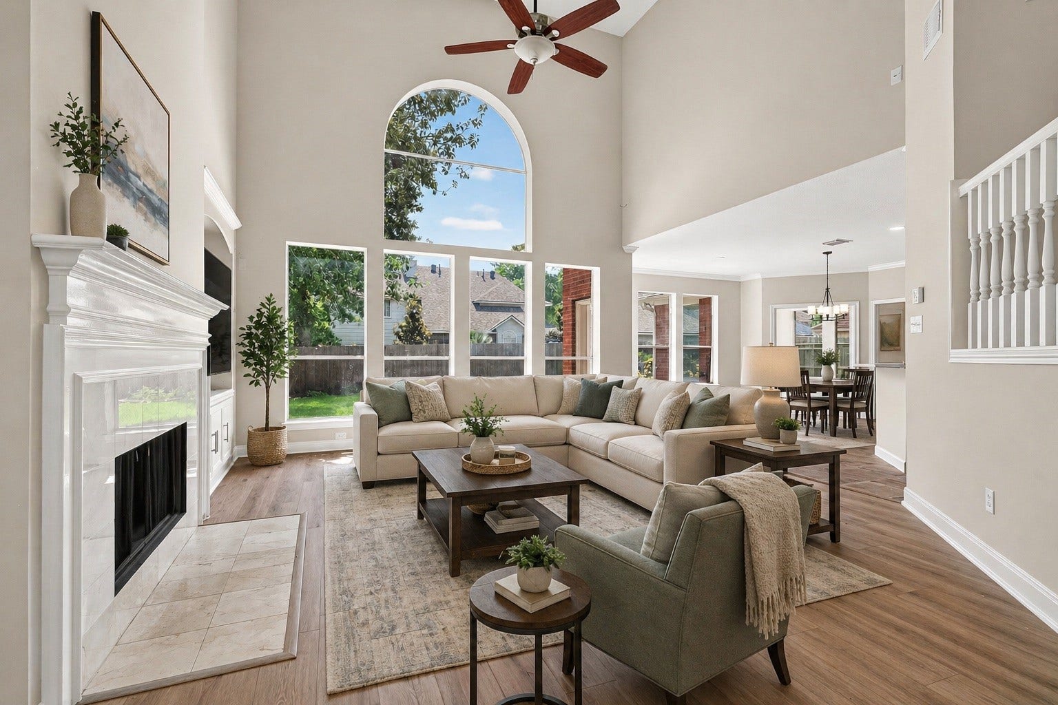 3610 Forest Row Drive, Houston, TX 77345 Stunning open-concept living area with soaring ceilings and large windows, flooding the space with natural light. The elegant fireplace and spacious seating area create a warm and inviting atmosphere, perfect for entertaining. (Virtually staged)