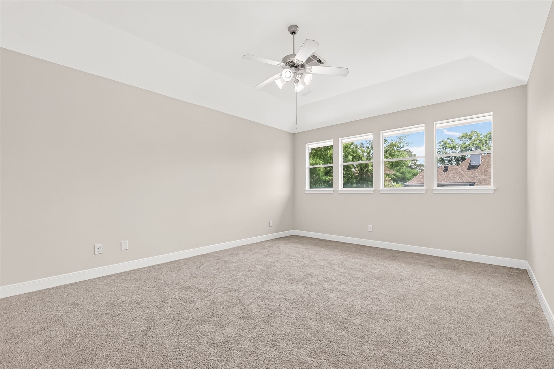 3610 Forest Row Drive, Houston, TX 77345 Spacious bedroom with a vaulted ceiling, plush carpet, and abundant natural light streaming through four large windows.