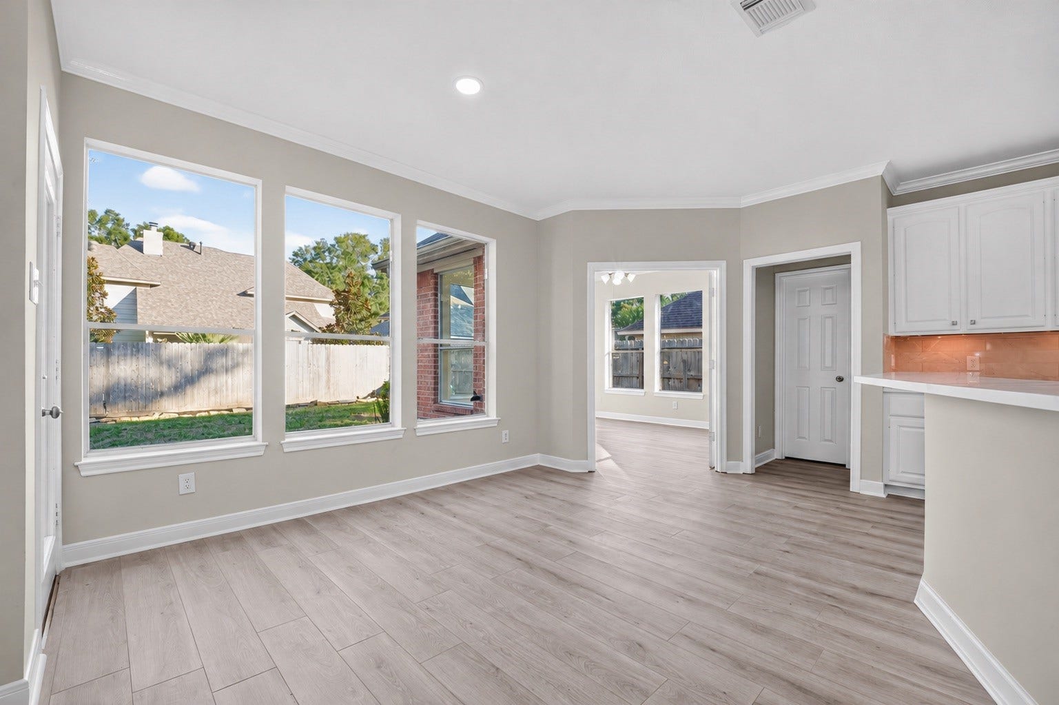 3610 Forest Row Drive, Houston, TX 77345 Bright breakfast area with tall windows overlooking the backyard, crown molding, and wood-look flooring. Conveniently located beside the kitchen and adjoining flex room. Small floor rug digitally removed.