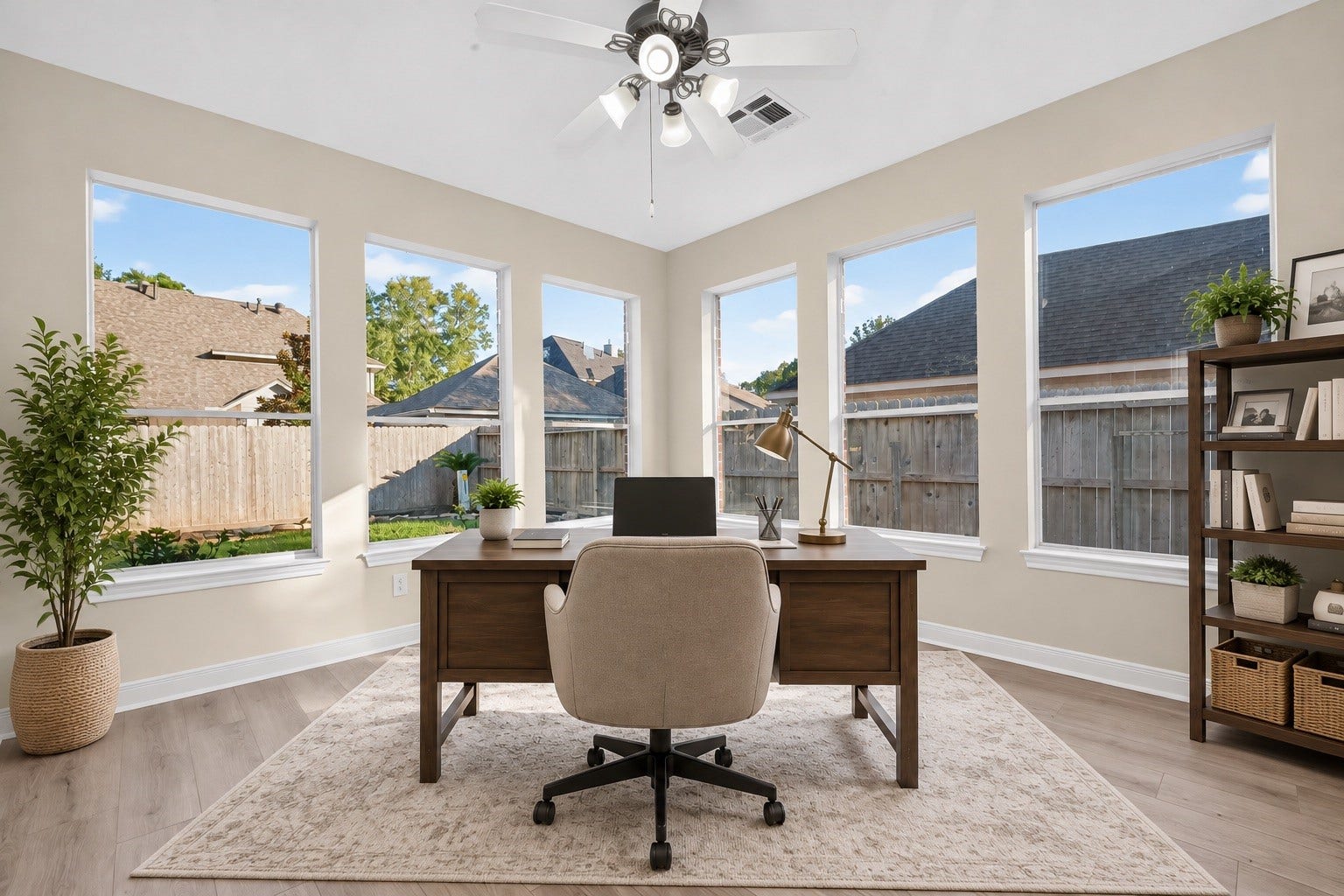 3610 Forest Row Drive, Houston, TX 77345 Virtually staged as a home office, this bright flex room features tall windows on two walls, backyard views, wood-look flooring, and a ceiling fan. Furniture and decor are digitally added.