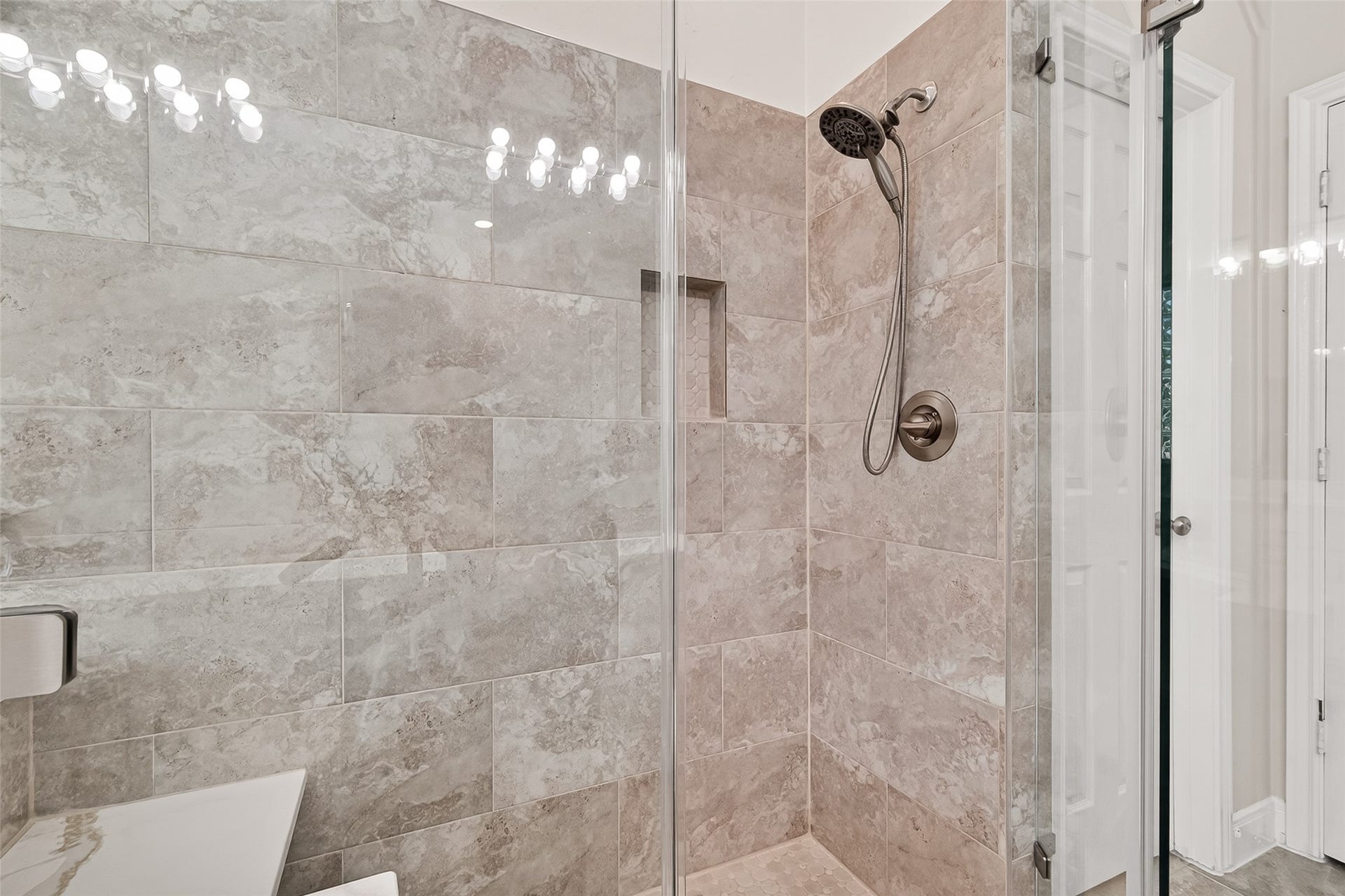 3610 Forest Row Drive, Houston, TX 77345 Experience modern elegance in this bathroom featuring a sleek, glass-enclosed shower with luxurious tile and a contemporary showerhead.