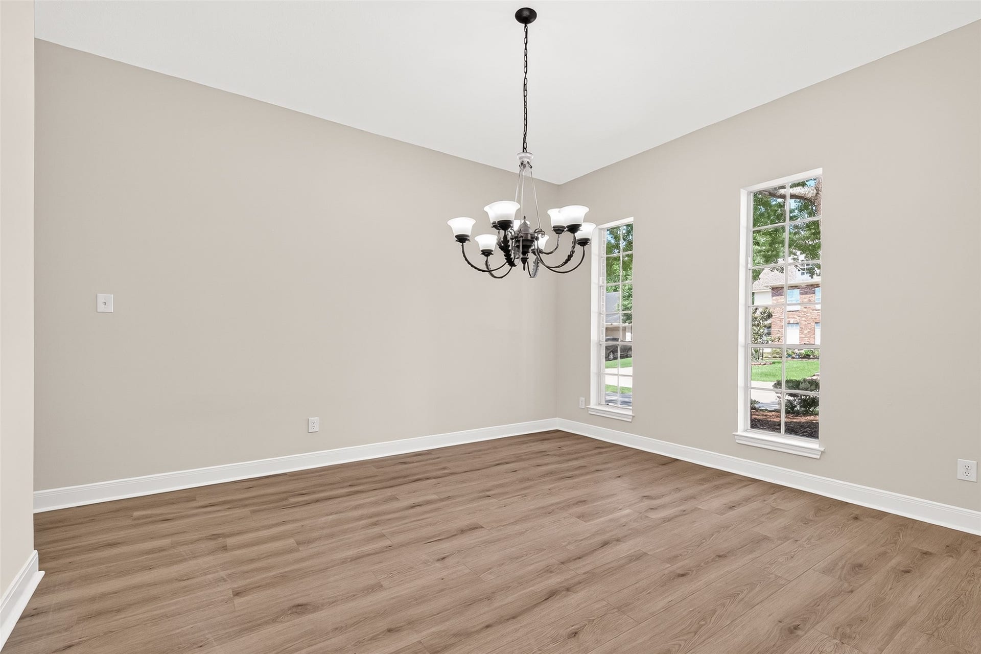 3610 Forest Row Drive, Houston, TX 77345 Bright room with elegant chandelier, large windows, and stylish wood flooring.