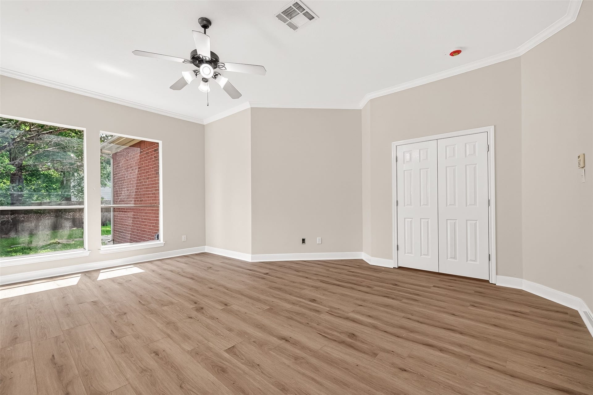 3610 Forest Row Drive, Houston, TX 77345 Bright and spacious room featuring large windows, elegant wood flooring, and a ceiling fan, perfect for a cozy living area or home office.