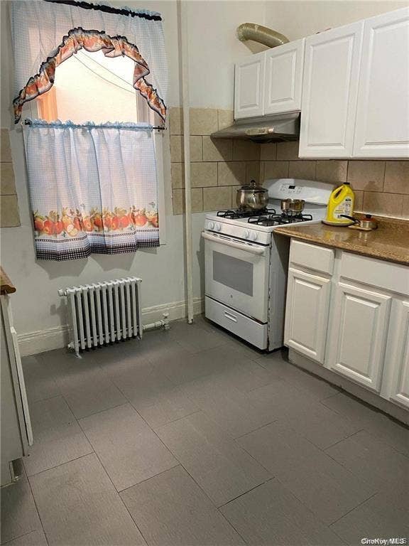 3138 103rd Street, #2ND FL, Corona, NY 11368 White cabinetry, gas range, metal range hood, stone-finish countertops, and tile flooring