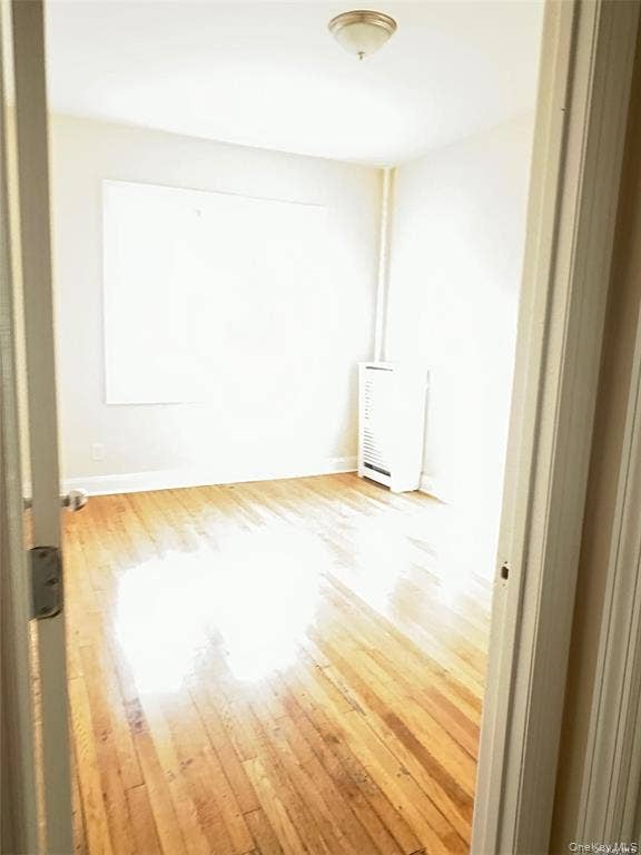 3138 103rd Street, #2ND FL, Corona, NY 11368 Hardwood flooring, flush-mount ceiling light fixture, baseboard heating unit, white wall finish