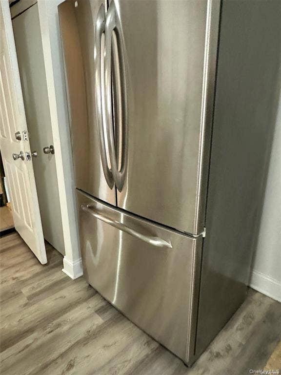 3138 103rd Street, #2ND FL, Corona, NY 11368 Stainless steel French door refrigerator with a bottom freezer drawer, complemented by wood-finish flooring
