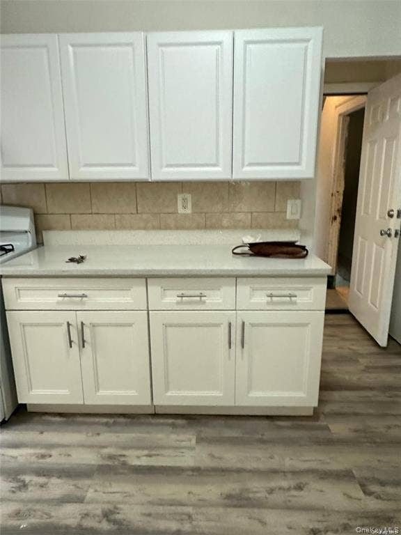 3138 103rd Street, #2ND FL, Corona, NY 11368 White upper and lower cabinetry, light-toned countertop, tile backsplash, and wood-finish flooring