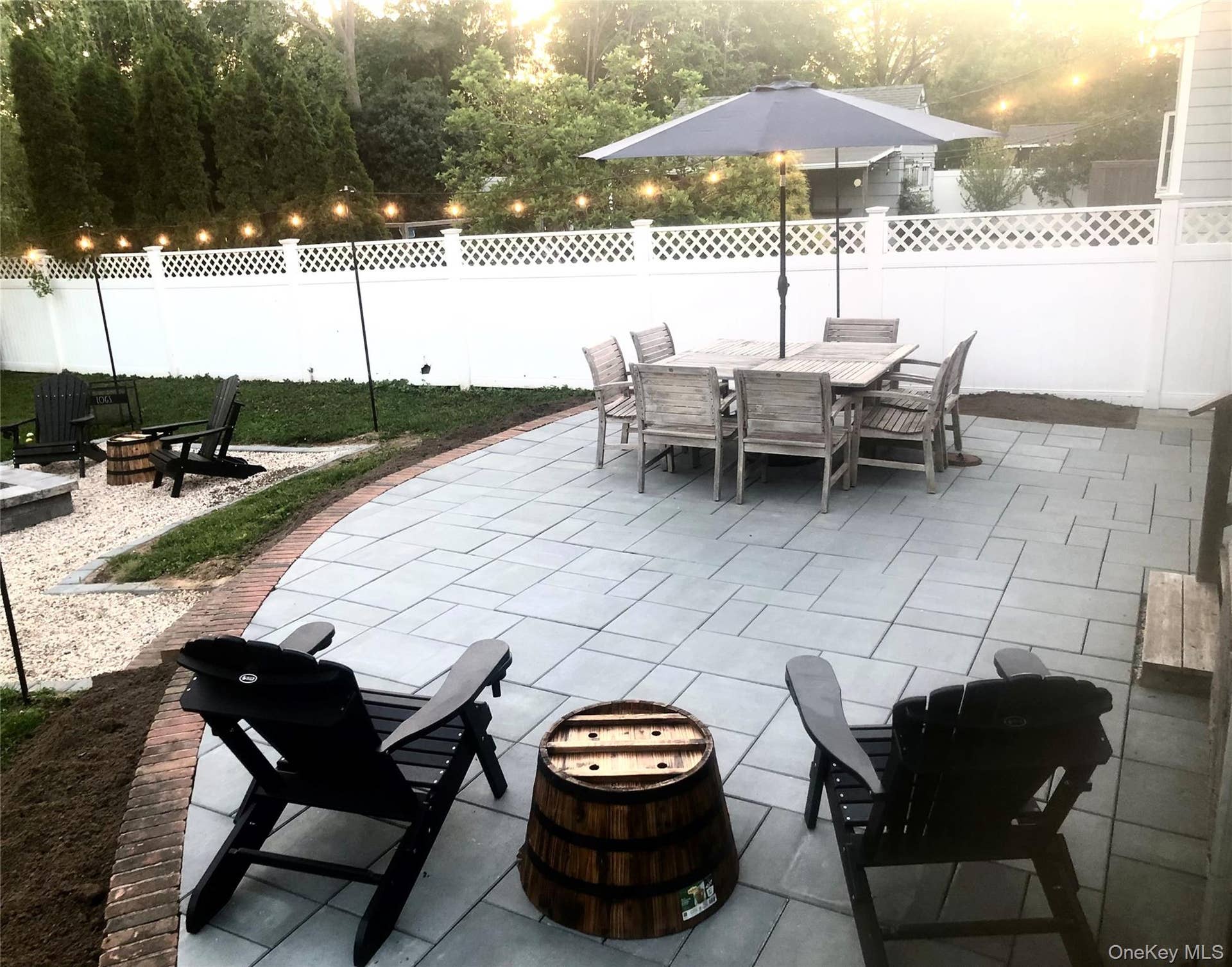 Fenced backyard featuring a fire pit, a patio, and outdoor dining area