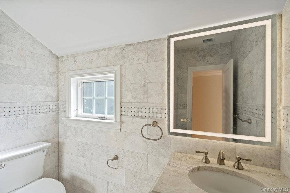 89 Mill River Road, Upper Brookville, NY 11771 Bathroom with vanity and tile walls