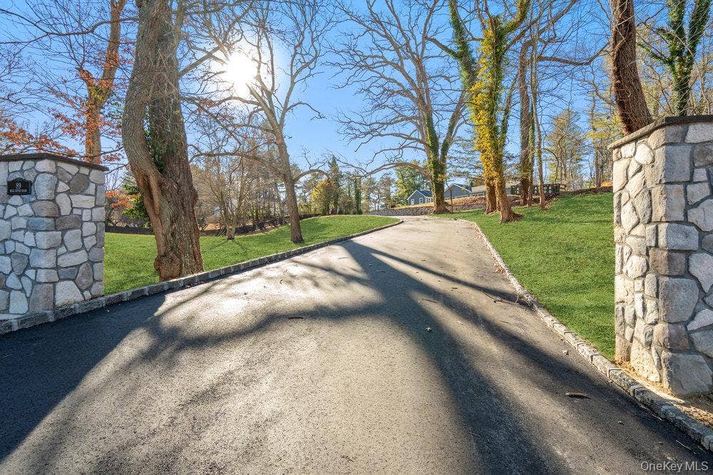 89 Mill River Road, Upper Brookville, NY 11771 View of asphalt driveway with curbs