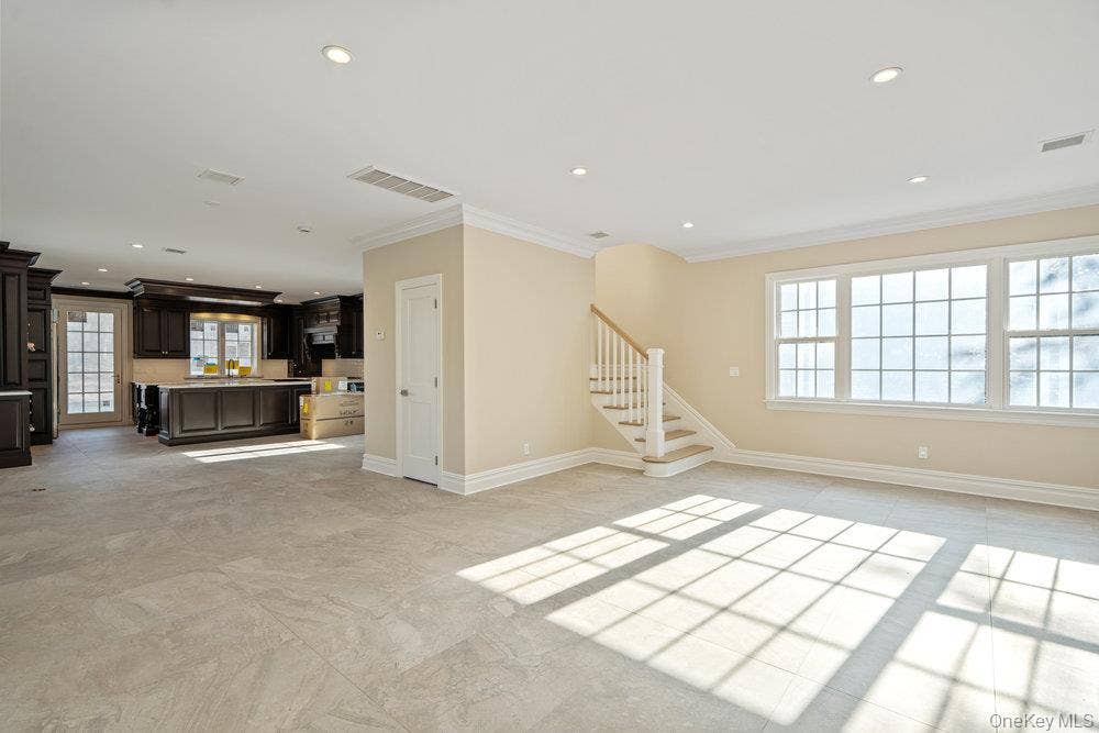 89 Mill River Road, Upper Brookville, NY 11771 Unfurnished living room with crown molding, stairway, and recessed lighting