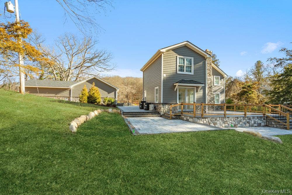 89 Mill River Road, Upper Brookville, NY 11771 Rear view of house with a yard, a patio, and a wooden deck