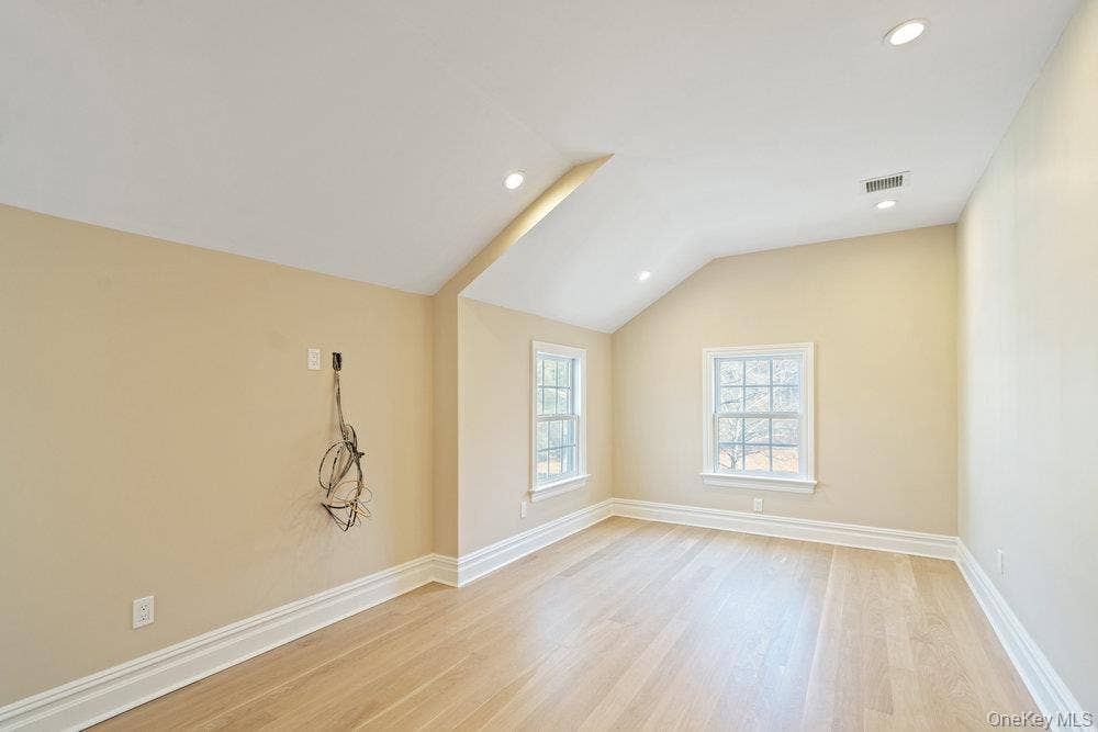 89 Mill River Road, Upper Brookville, NY 11771 Empty room with lofted ceiling, light wood-style floors, and recessed lighting
