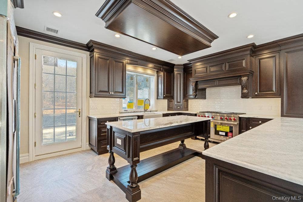 89 Mill River Road, Upper Brookville, NY 11771 Kitchen with dark brown cabinetry, backsplash, crown molding, and recessed lighting