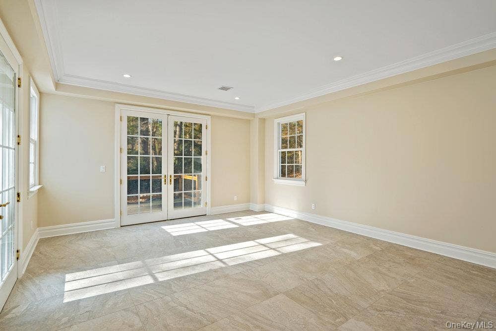 89 Mill River Road, Upper Brookville, NY 11771 Unfurnished room with french doors, crown molding, recessed lighting, and light marble finish floors