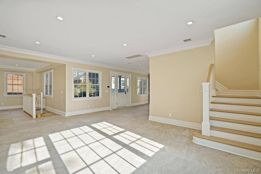 89 Mill River Road, Upper Brookville, NY 11771 Unfurnished living room featuring stairway, recessed lighting, plenty of natural light, and ornamental molding
