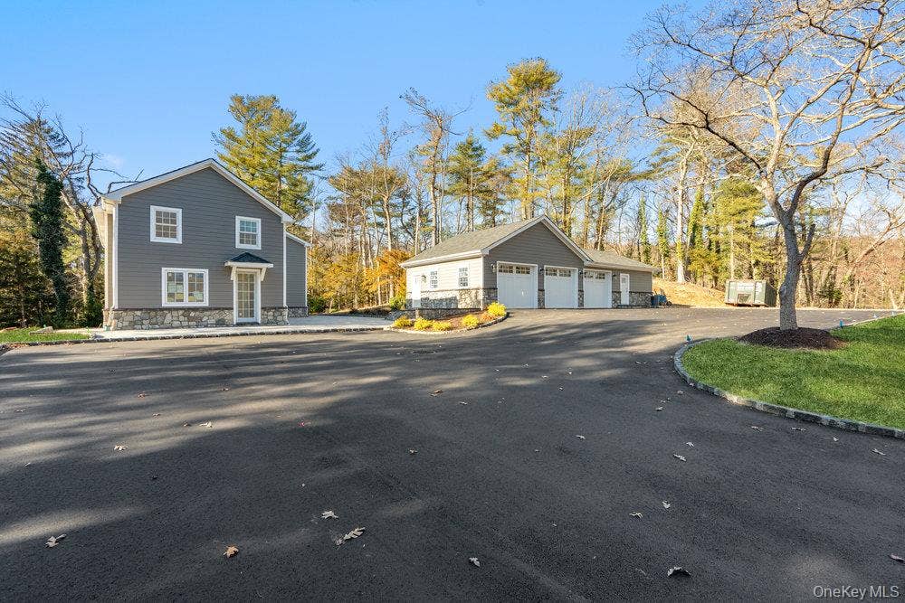 89 Mill River Road, Upper Brookville, NY 11771 View of side of property with an outbuilding and a garage